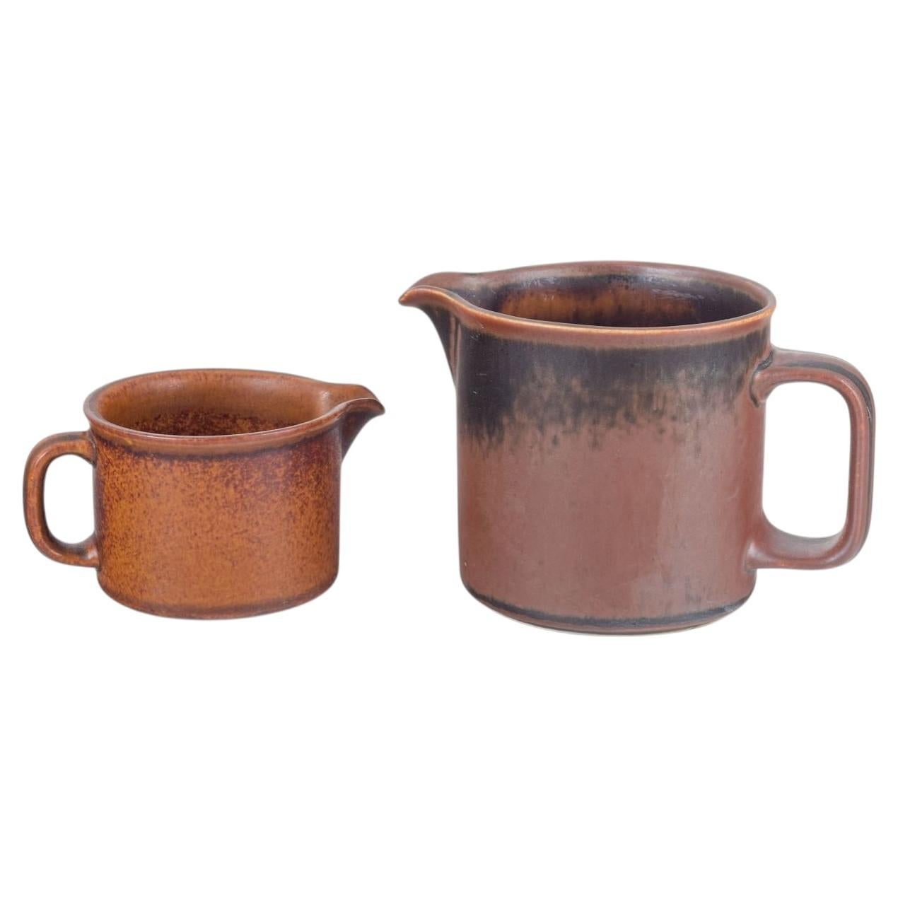 Ulla Procopé for Arabia. Two stoneware pitchers with brown glaze. 1970s. For Sale