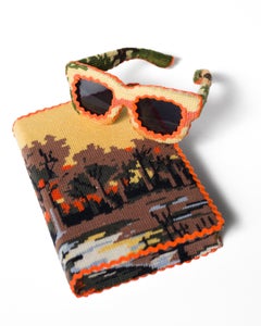 "Tarde", bordado de paisaje forestal que cubre libro y gafas de sol