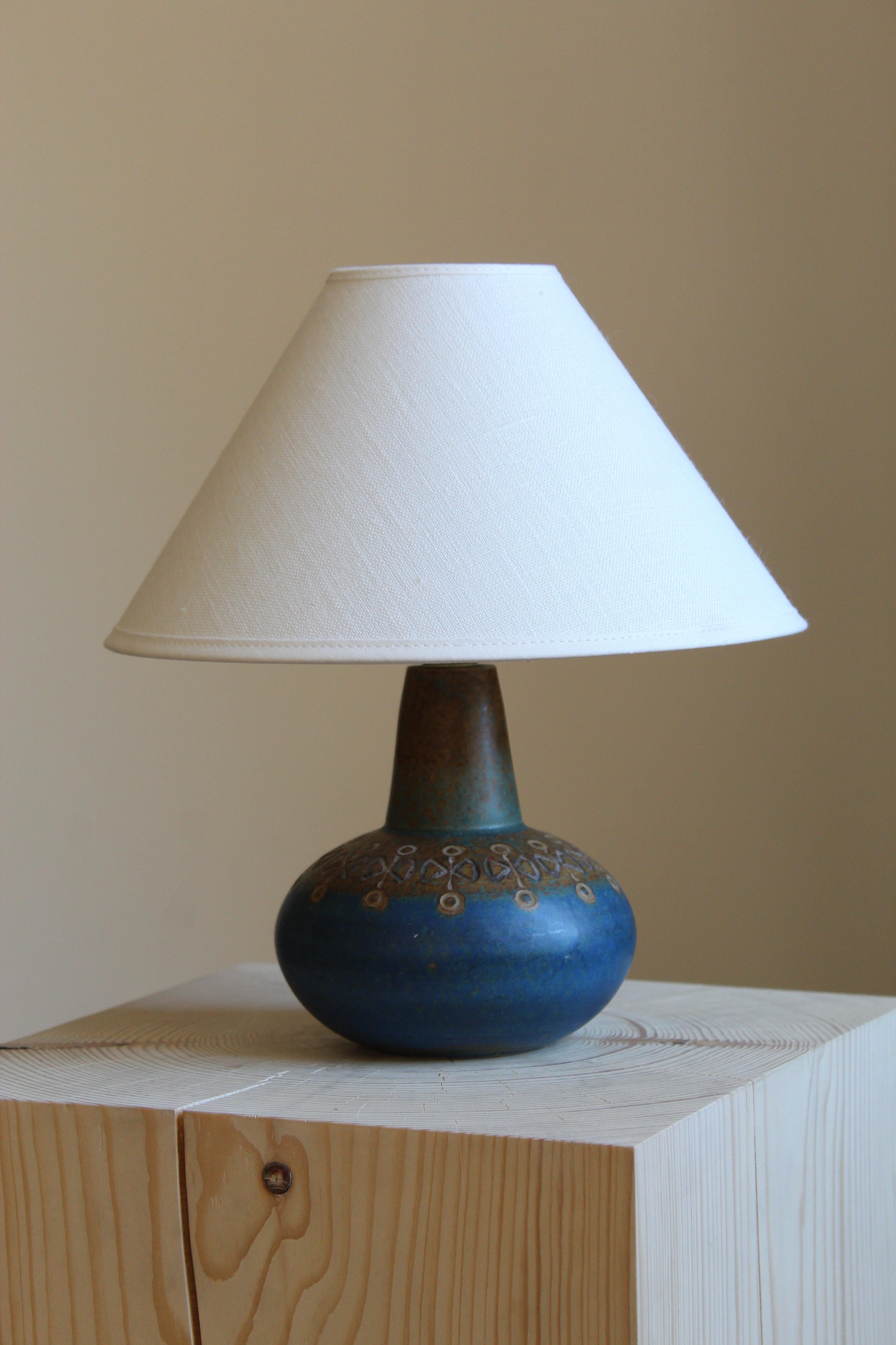 A table lamp by Ulla Winblad. Handcrafted in stoneware by Allingsås Keramik, Sweden, c. 1950s

Glaze features blue-brown colors.

Sold without lampshade. Stated dimensions exclude lampshade. 