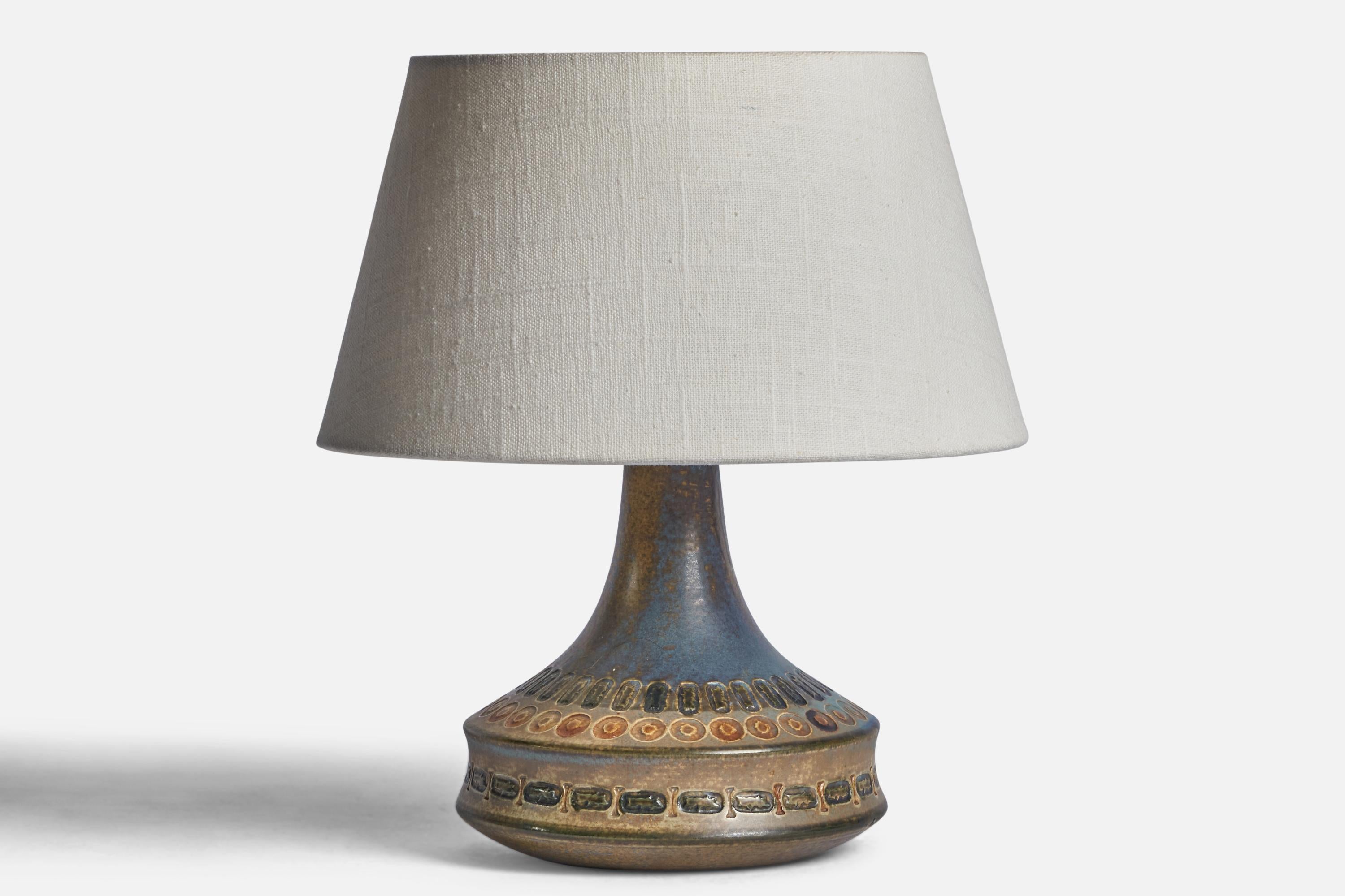 A blue and beige-glazed and incised table lamp designed by Ulla Winbladh and produced by Alingsås Keramik, Sweden, c. 1960s.

Dimensions of Lamp (inches): 8.25” H x 6.15” Diameter

Dimensions of Shade (inches): 7” Top Diameter x 10” Bottom Diameter