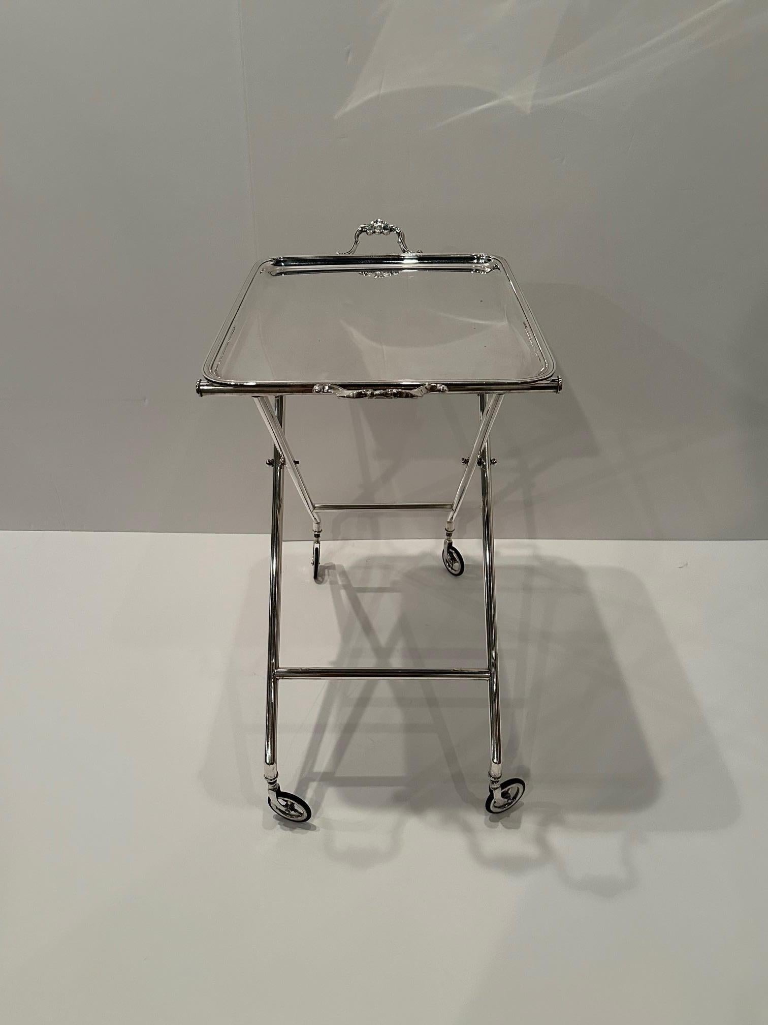 Chic silverplated metal tray on a stand or bar cart having removeable tray with lovely handles and sleek base on wheels.
27