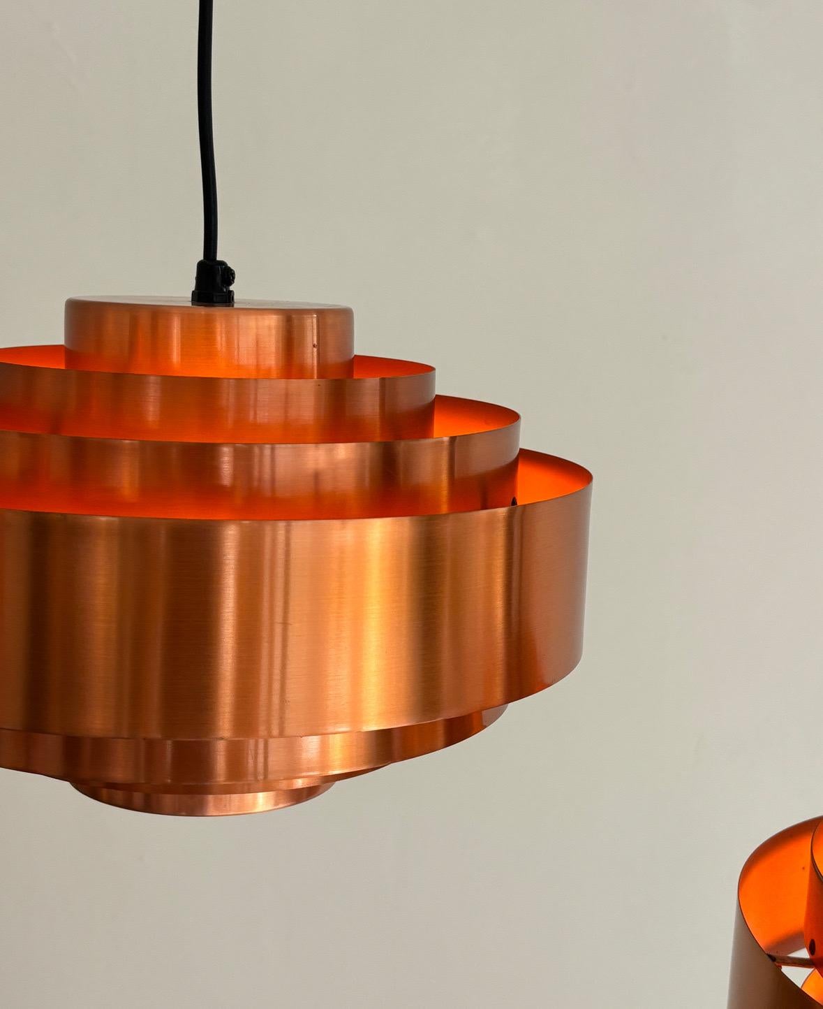 Il ciondolo Ultra Copper di Jo Hammerborg per Fog & Mørup è la quintessenza del design dell'illuminazione moderna danese degli anni '60. Realizzata in rame filato con un interno di colore arancione caldo, la sua forma scultorea a più livelli