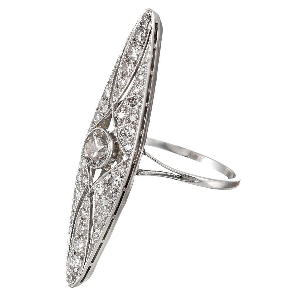 The elongated and feminine “navette” shape looks elegant on the finger, similar to an exaggerated marquis. The design is centered upon a .66 carat old European cut diamond that exhibits K color with Vs2 clarity. A additional .90 carats of old