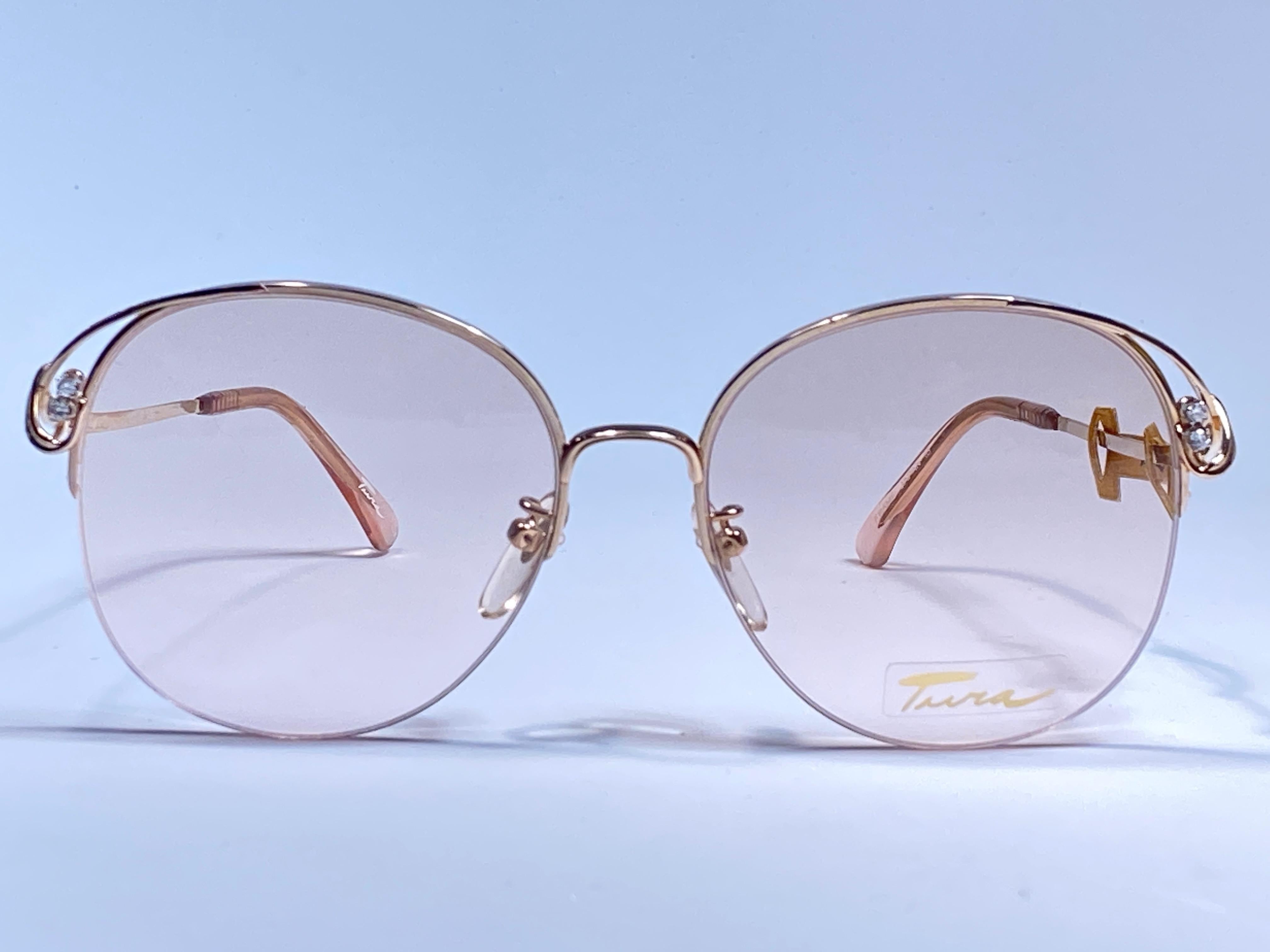 Tura 12K gold filled with clear rhinestones sunglasses circa 1970's. Half Frame with RX lenses.

This is a seldom and rare piece not only for its aesthetic value but for its importance in the sunglasses and fashion history.   

Please notice this