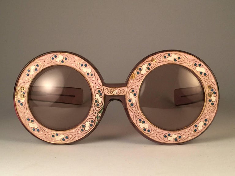 Ultra rare pair of Christian Dior Sunglasses circa 1969.

This is a seldom and rare piece not only for its aesthetic value but for its importance in the sunglasses and fashion history. 

Delicate enamel ornamented plate over an Optyl round oversized