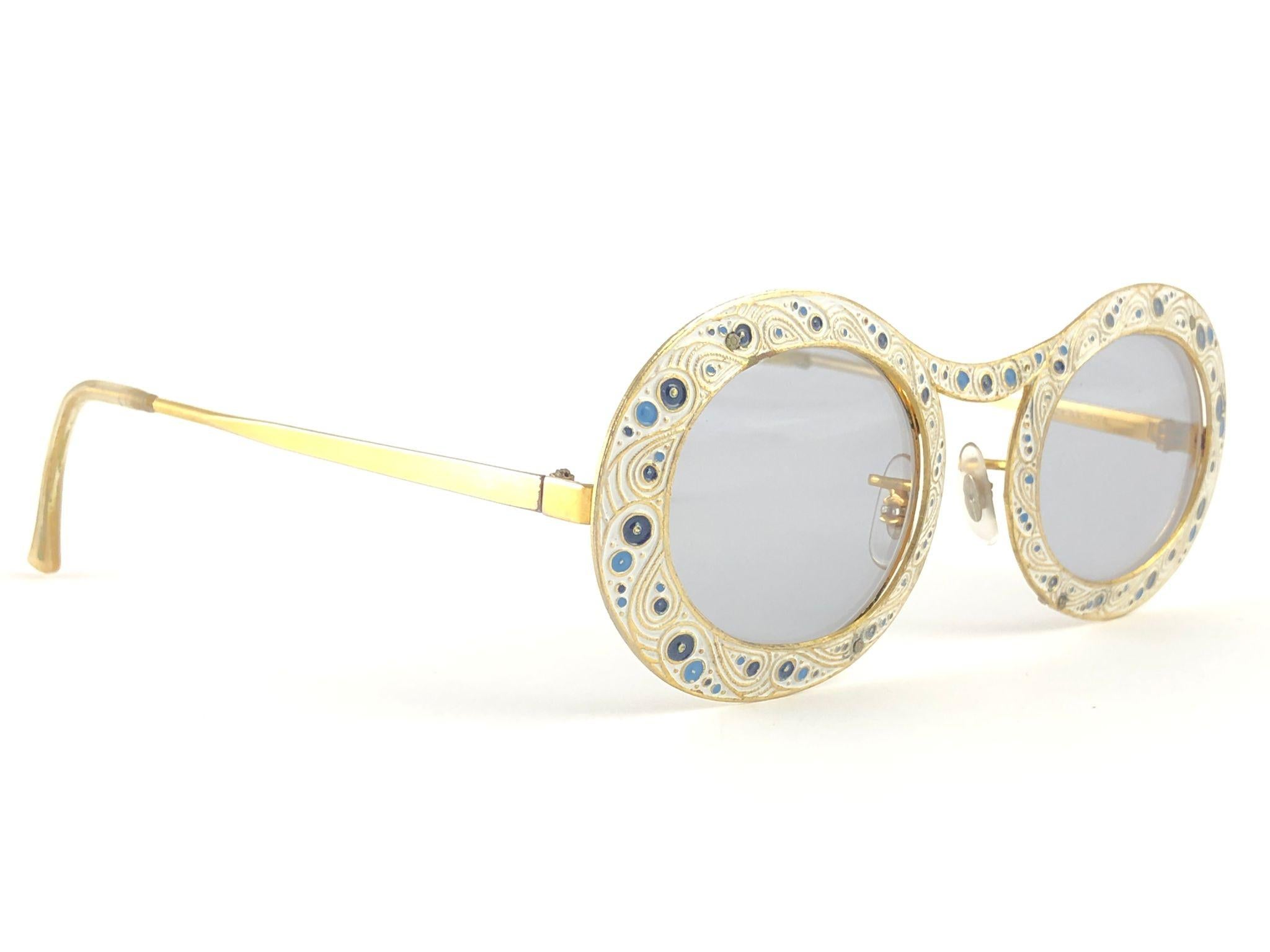 Ultra rare pair of Christian Dior Sunglasses circa 1969. 12K Gold filled frame.

This is a seldom and rare piece not only for its aesthetic value but for its importance in the sunglasses and fashion history. 

Delicate enamel ornamented plated