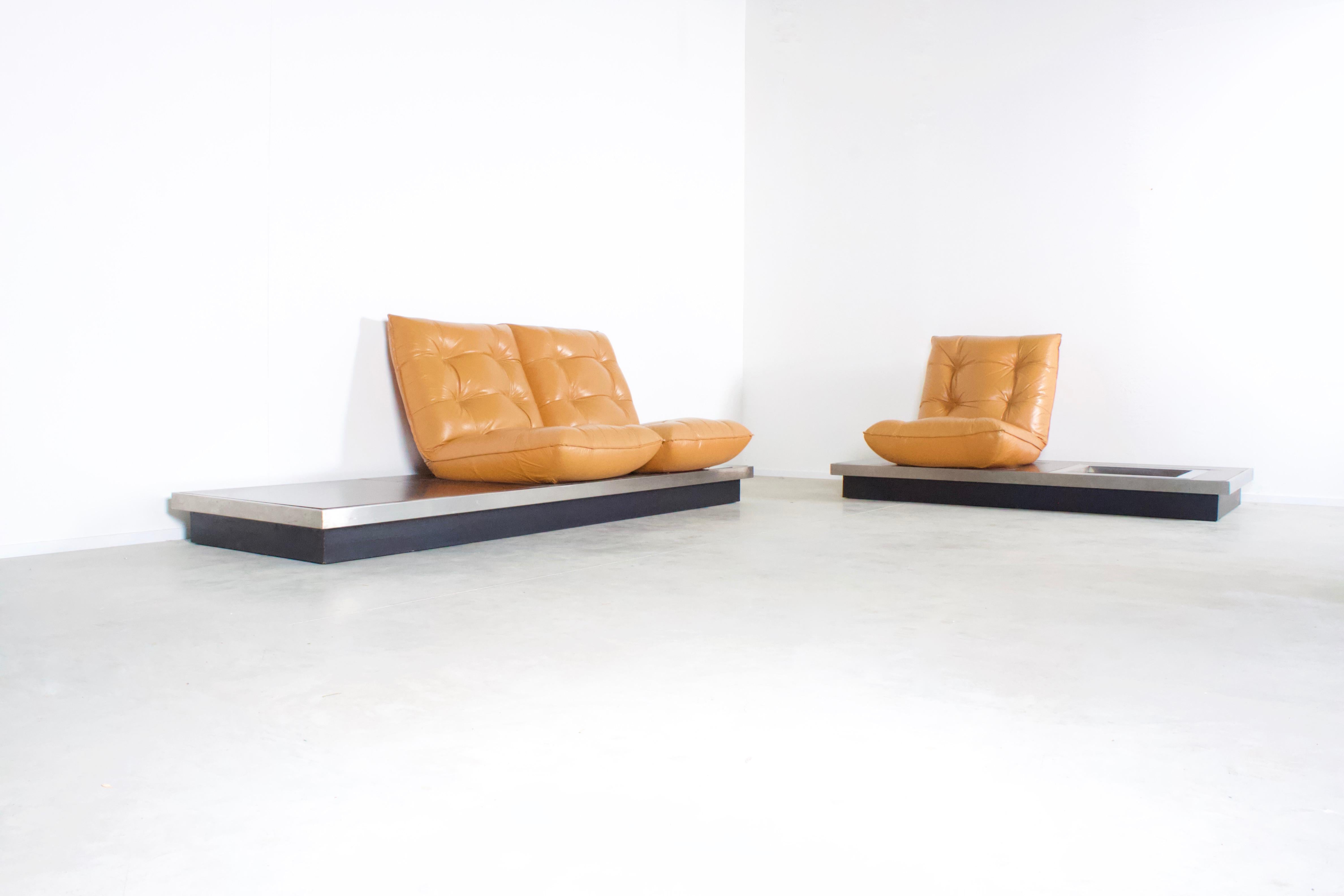 Set of ultra rare Michel Ducaroy platform sofas in very good condition.

Manufactured in France in the 1970s 

The sofas consist of a low platform made of black laminated wood and a stainless steal frame.

The platform carries comfortable cognac