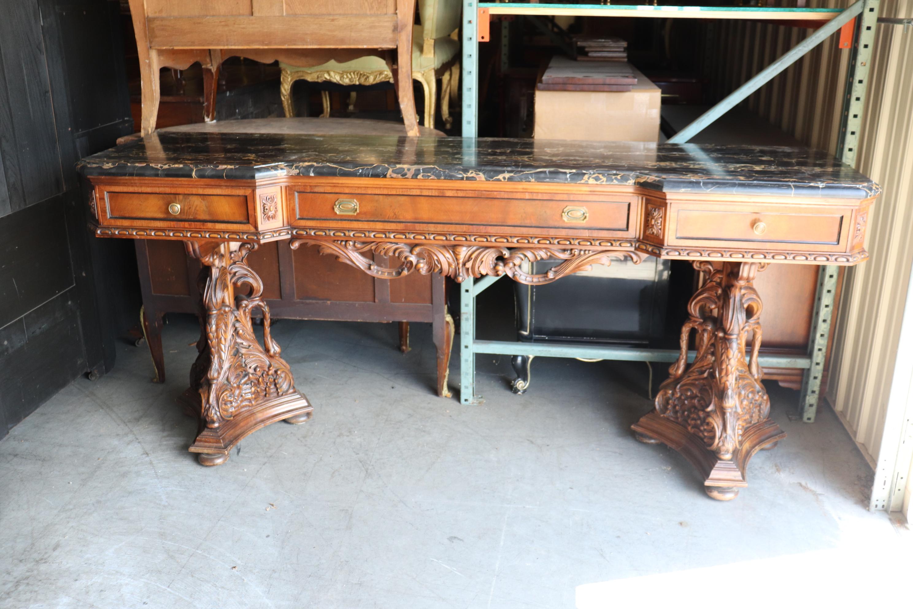 This is a very very rare form of sideboard that you may never see again. The base of the sideboard are carved swans holing up the top section which holds silverware and a slab or Italian portoro marble. The piece is in very good condition for its