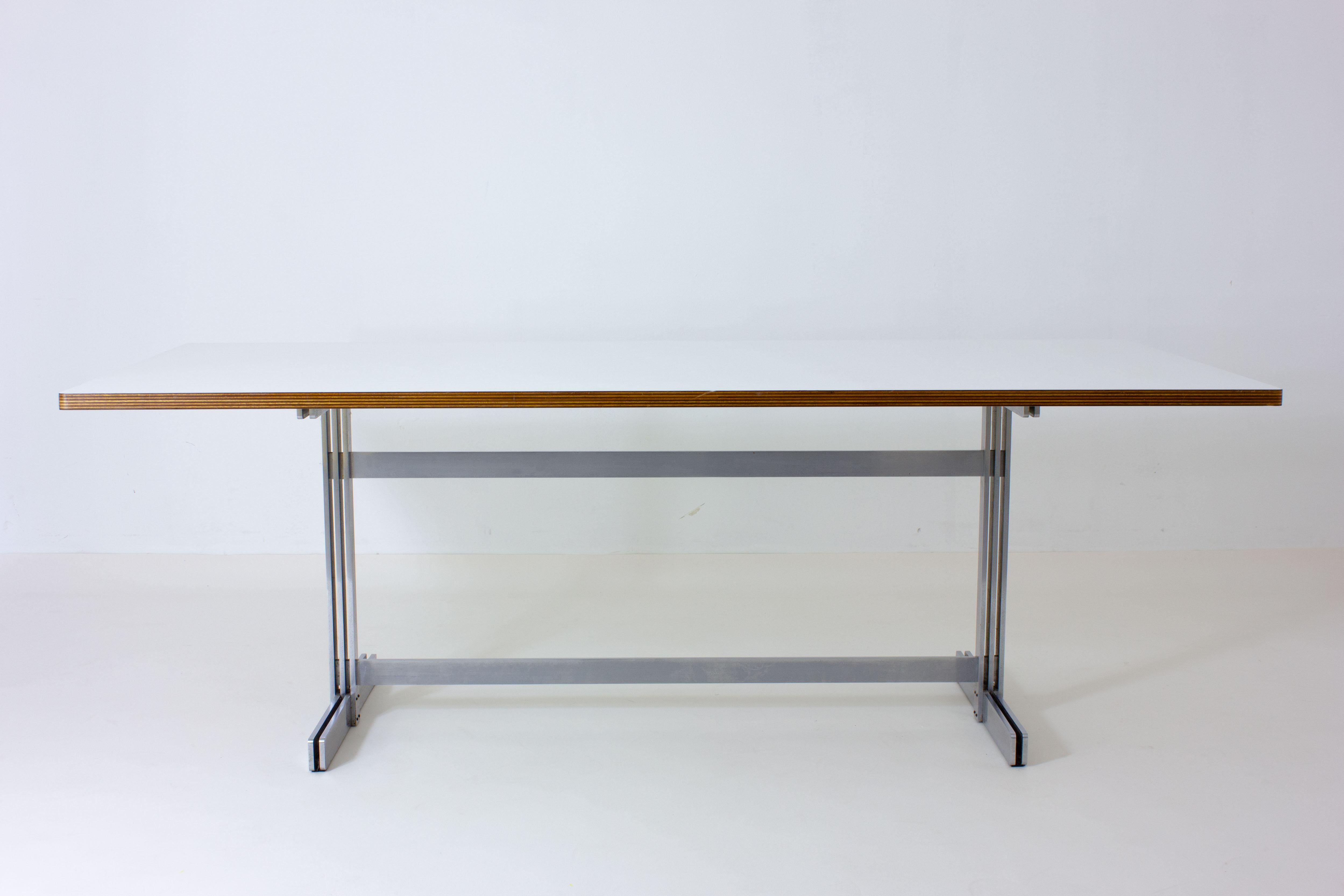 This exclusive white laminated dining table was designed by Jules Wabbes for Mobilier Universel in 1959. Known for its mid-century style, Wabbes been featured in the most notable design museums across the world. Designed to seat eight people, this