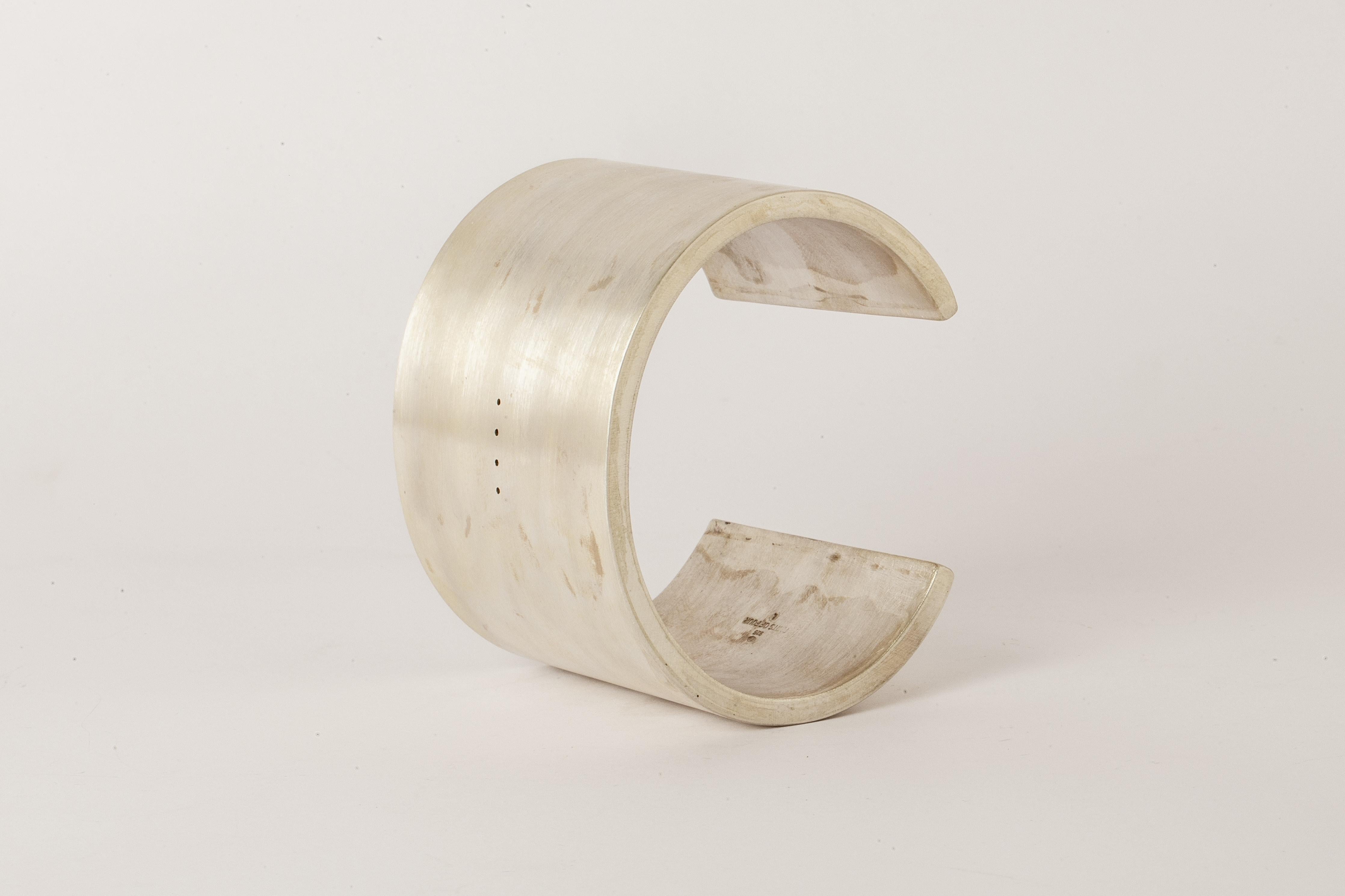 Bracelet in matte sterling silver, sanded at 320 grit. This piece is 100% hand fabricated from metal plate; cut into sections and soldered together to make the hollow three dimensional form. If sterling silver, the sheet metal is made by hand. The