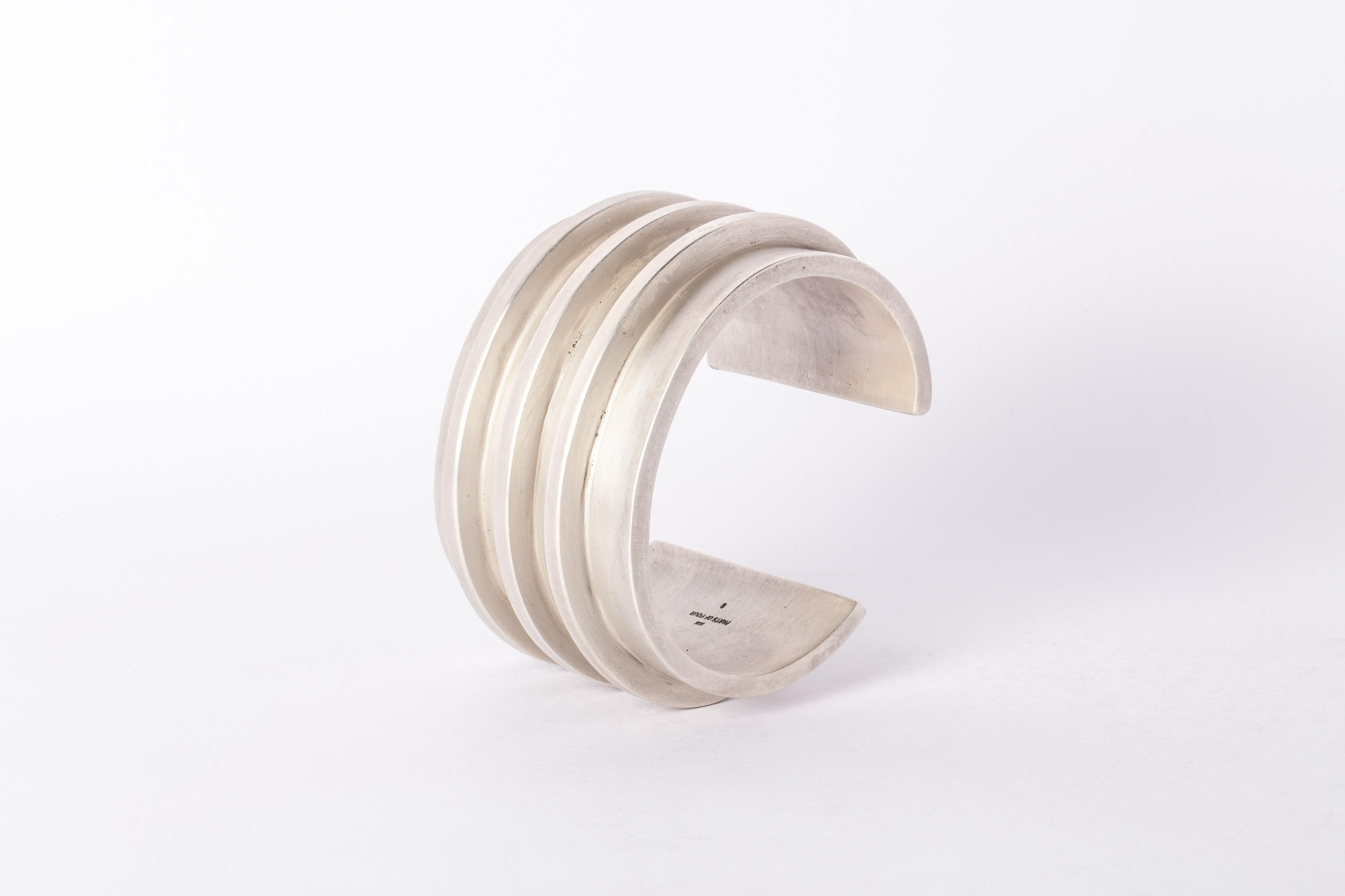 Bracelet in acid treated sterling silver. This piece is 100% hand fabricated from metal plate; cut into sections and soldered together to make the hollow three dimensional form. If sterling silver, the sheet metal is made by hand. The silver is