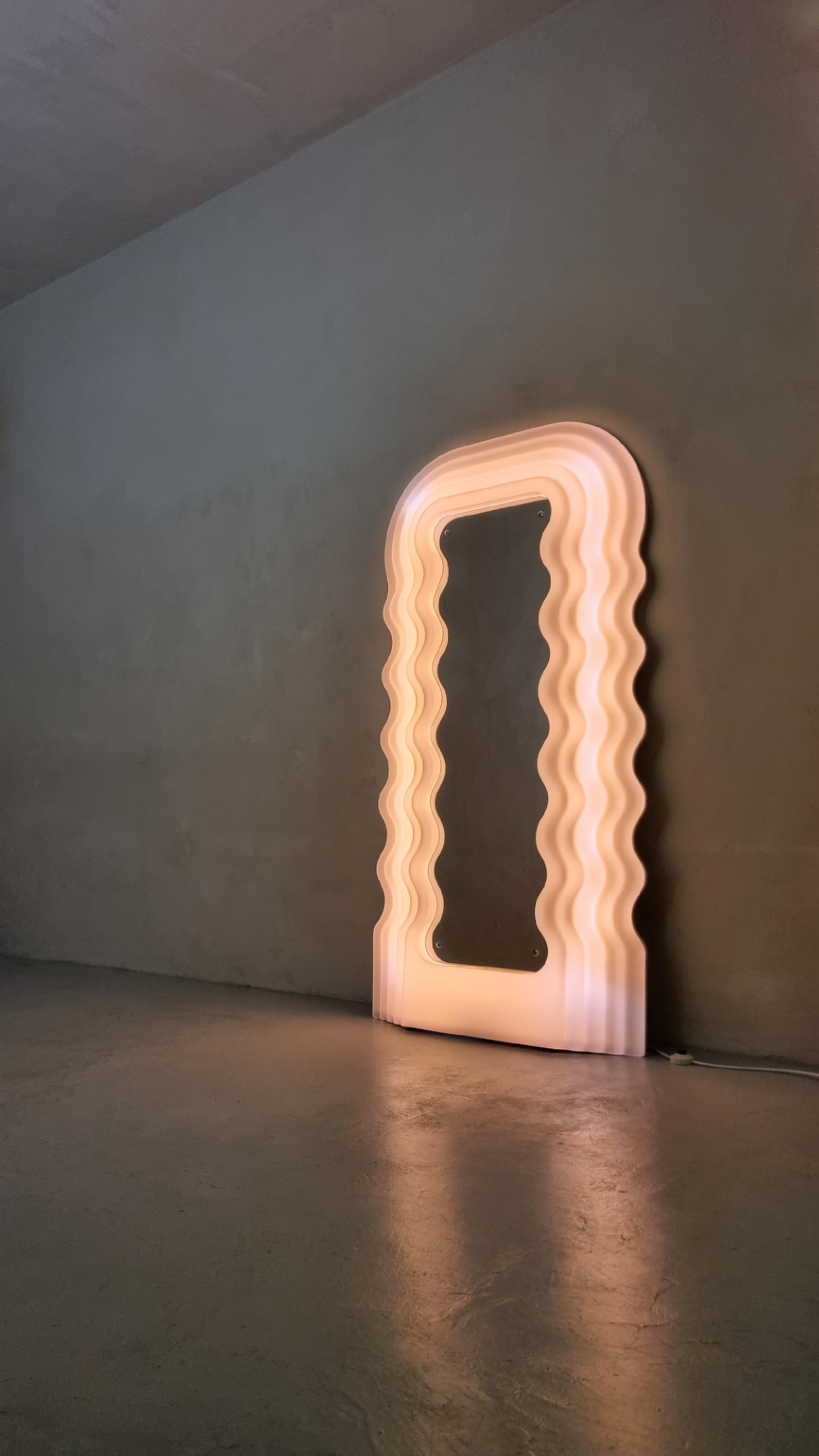 Icónico espejo iluminado Ultrafragola diseñado por Ettore Sottsass para Poltronova, 1980.
Marco de metacrilato, lámparas de neón, cristal de espejo, madera pintada. Excelente estado, primera producción con panel de madera pintada e iluminación de