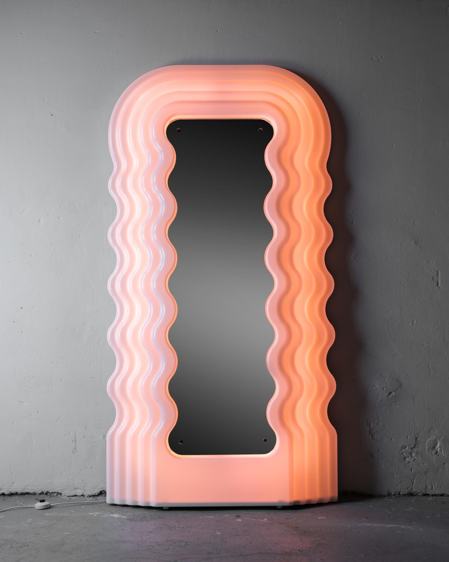 Designed in 1970 for Poltronova, the Ultrafragola is a Large illuminated mirror made of an acrylic profile resembling long wavy hair and backlit with a neon light system. The mirror was launched in the 70’s and was an absolute chocker, so much that