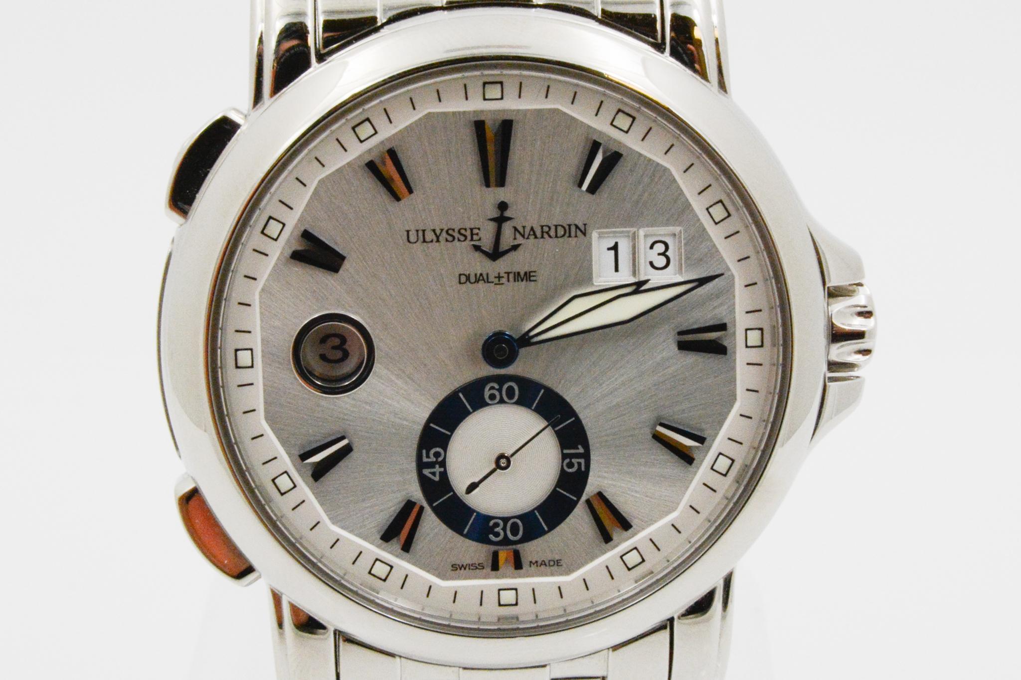 This CPO circa 2007 Ulysse Nardin Dualtime 40mm watch has a silver dial with blue index markers. It also has month and day window and a second hand subdial. The watch has a five row bracelet and automatic movement. Model: 243-55

