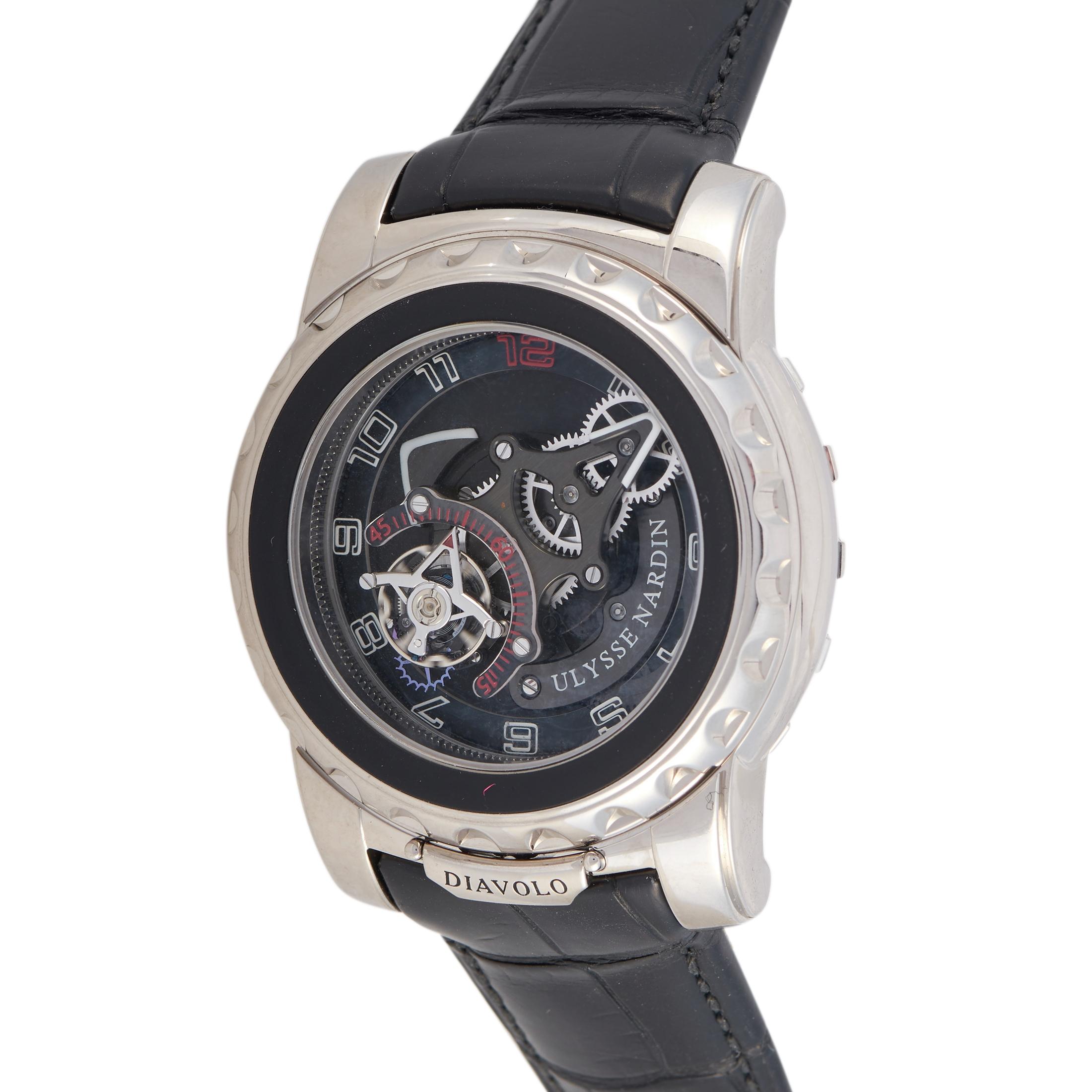 This is the Ulysse Nardin Freak Diavolo watch, reference number 2080-115.
 
 It comes with an 18K white gold case that is presented on a black alligator leather strap, secured on the wrist with a deployment clasp. The watch has no crown, and it is