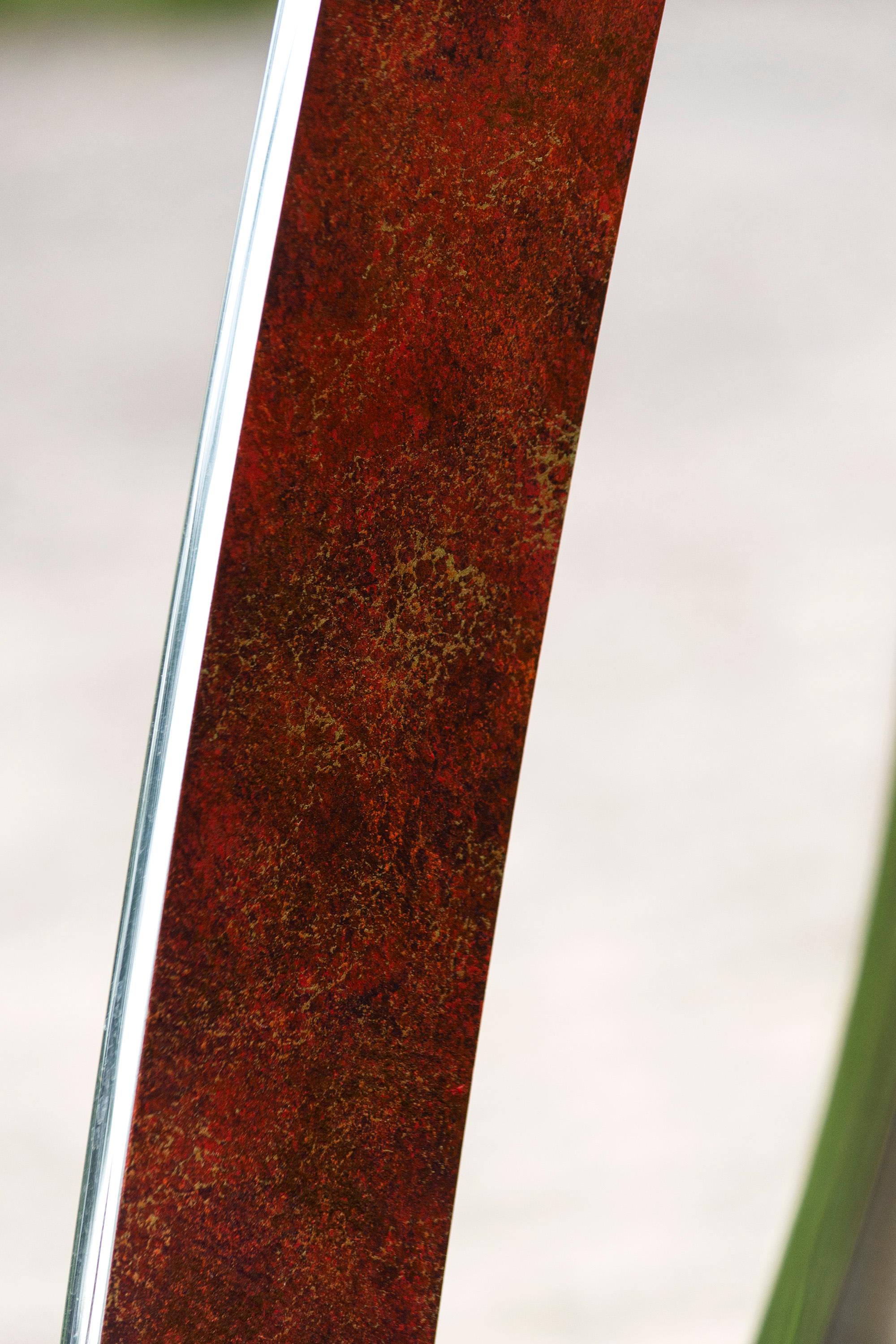This elegant and dynamic modern outdoor sculpture—a rare artist’s proof is by Toronto-based sculptor Ulysses Veloso. Three bands of polished stainless steel, the interior patinated in a rich textured burnt umber form seemingly infinite loops