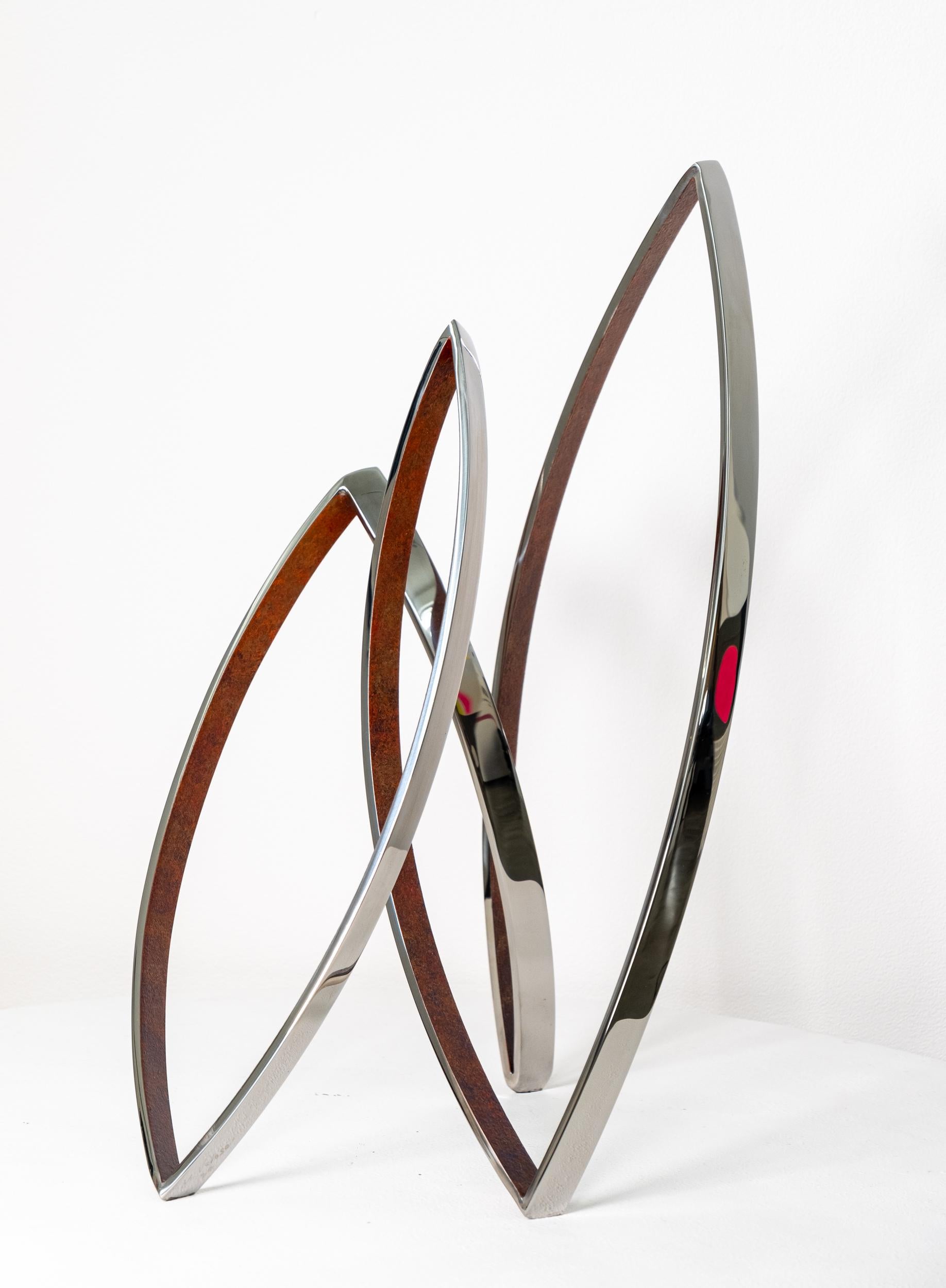 Questa elegante e dinamica scultura contemporanea in acciaio inossidabile è stata creata da Ulysses Veloso per emulare il calore e la forma di un falò. L'artista di Toronto ha forgiato a mano questa serie: ognuno dei tre anelli apparentemente