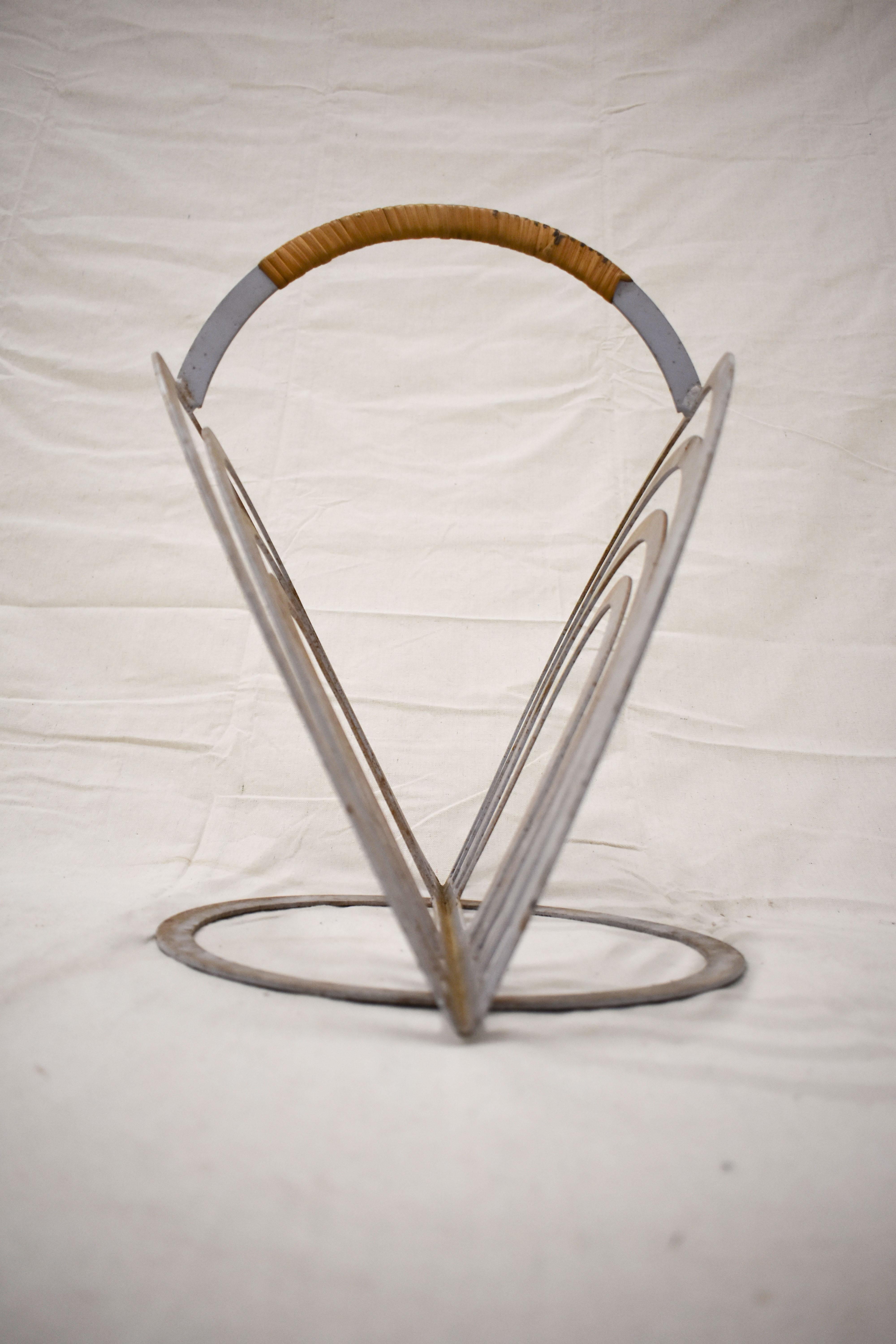 Rare Arthur Umanoff designed magazine rack utilizing his trademark rattan wrapped handle. In good vintage condition with surface rust consistent with use and age.