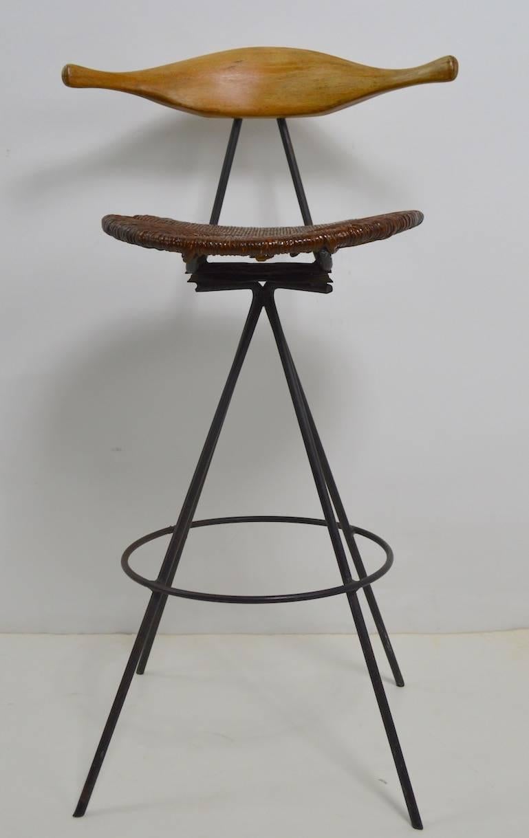 Rare cow horn back, swivel stool, on wrought iron base, designed by Arthur Umanoff. This is a hard to find form, with the sculpted wood backrest, cord seat, and splayed iron base. Pure midcentury style, original condition, clean ready to use. Finish