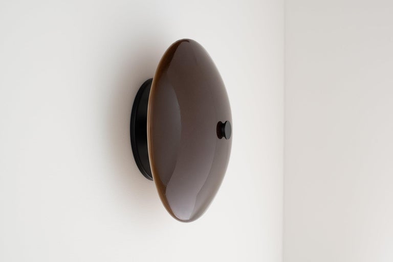 A modern dome of hand poured and slumped glass floats effortlessly off the wall providing distinct dimmable illumination. 

The Lyra sconce is available in multiple glass colors and illuminated by a 120V AC direct drive led module with no external