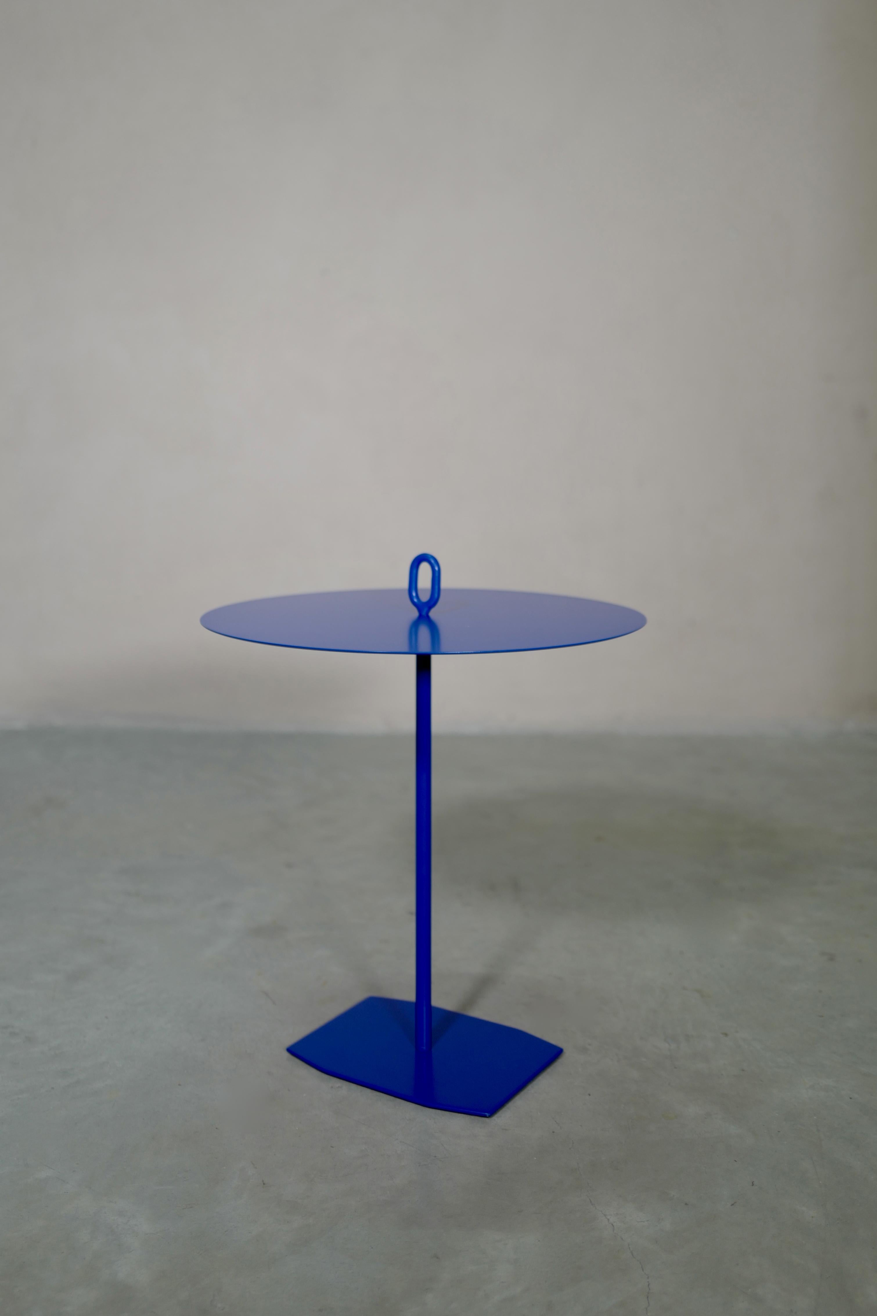 Small contemporary italian coffee table with eyelet. Steel pedestal rod and eyelet, aluminum top. “Signal blue” powder coated. The eyelet on the top allows the table to be moved easily even with objects on it. Other sample colors available on