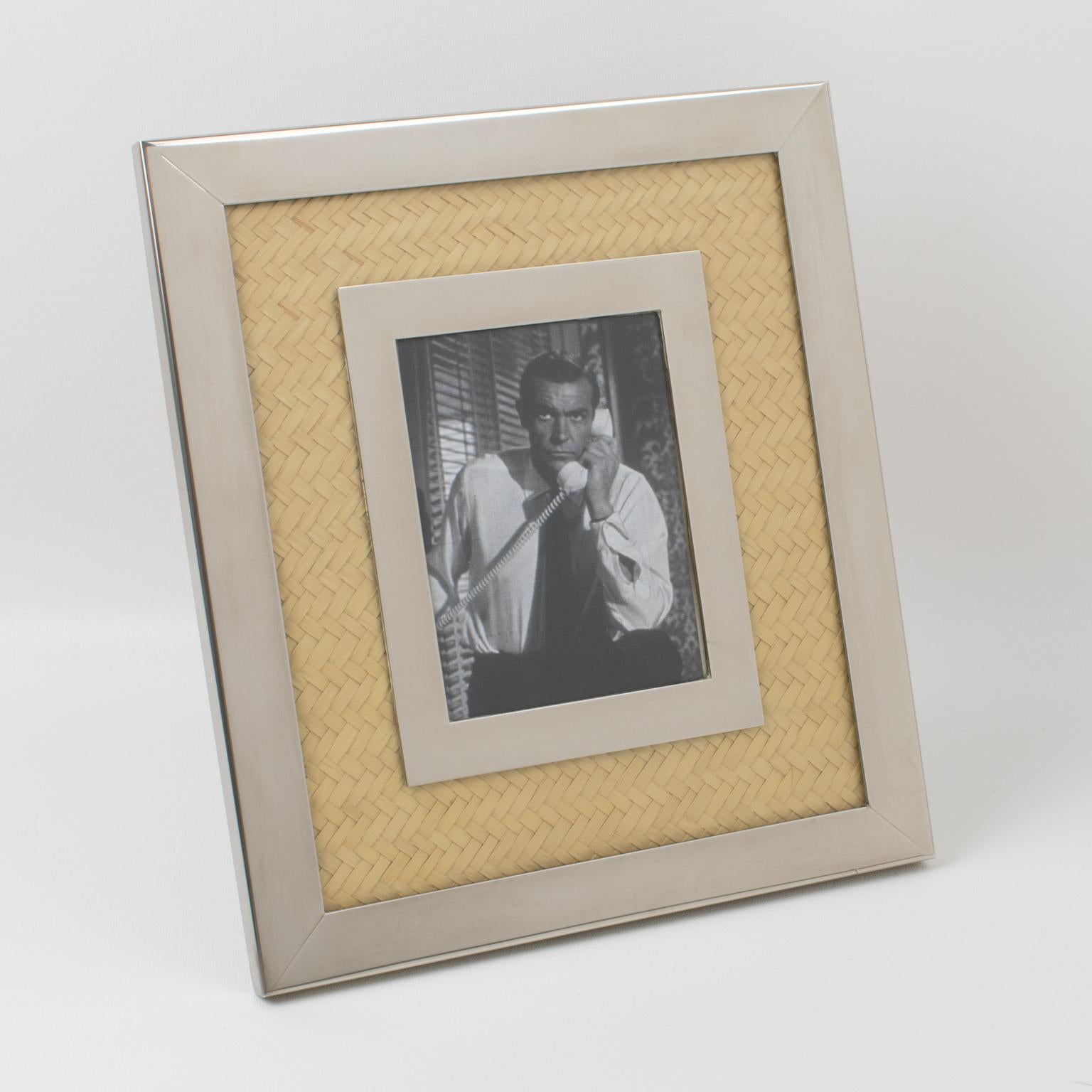 La empresa Umberto Mascagni, de Italia, diseñó este elegante marco de fotos en la década de 1970. La pieza presenta combinaciones de metal cromado y marquetería de paja. El caballete metálico de la parte trasera tiene un sistema giratorio que
