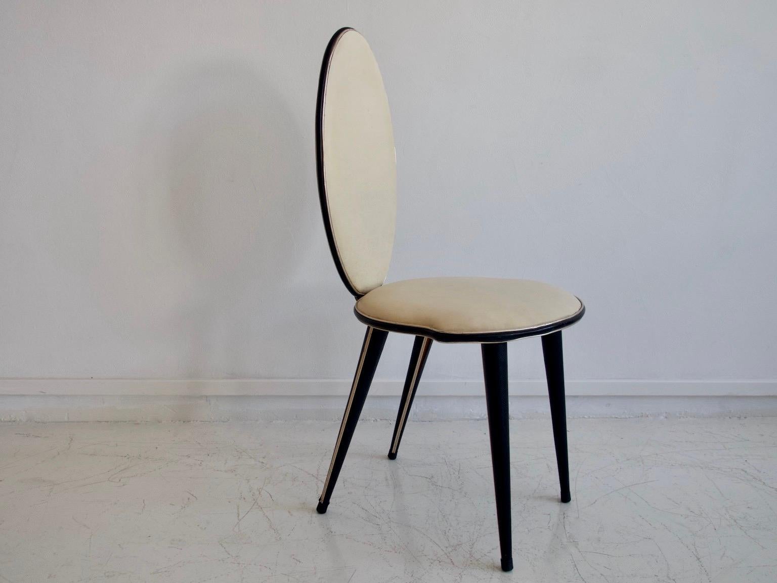 Chair from the 1950s, Italian design by Umberto Mascagni. Conical wooden legs covered with black vinyl and with inlaid golden metal trim. Seat and back covered in cream white vinyl with black edging. Traces of wear commensurate with age, some cracks