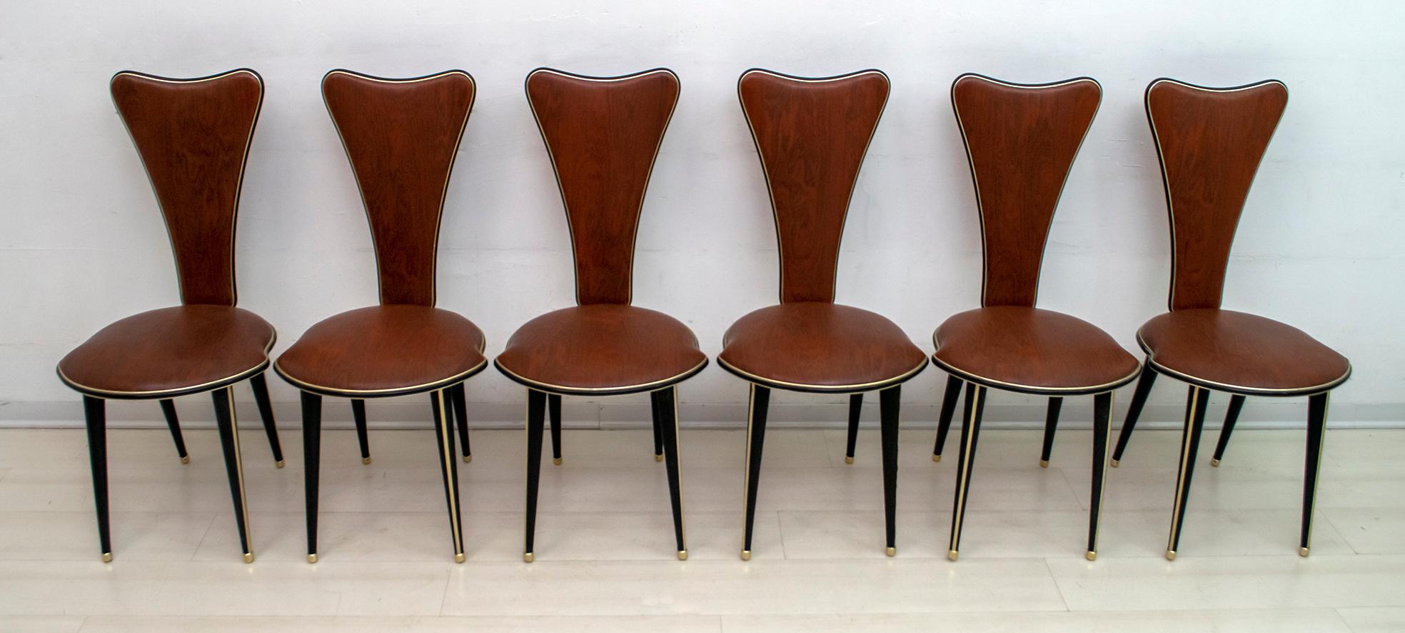 Six dining chairs designed by Umberto Mascagni of Bologna in the 1950s. The main body structure is in solid European wood, covered in brown veined vinyl and anodized aluminum. The legs are also covered in black vinyl. Excellent vintage condition.