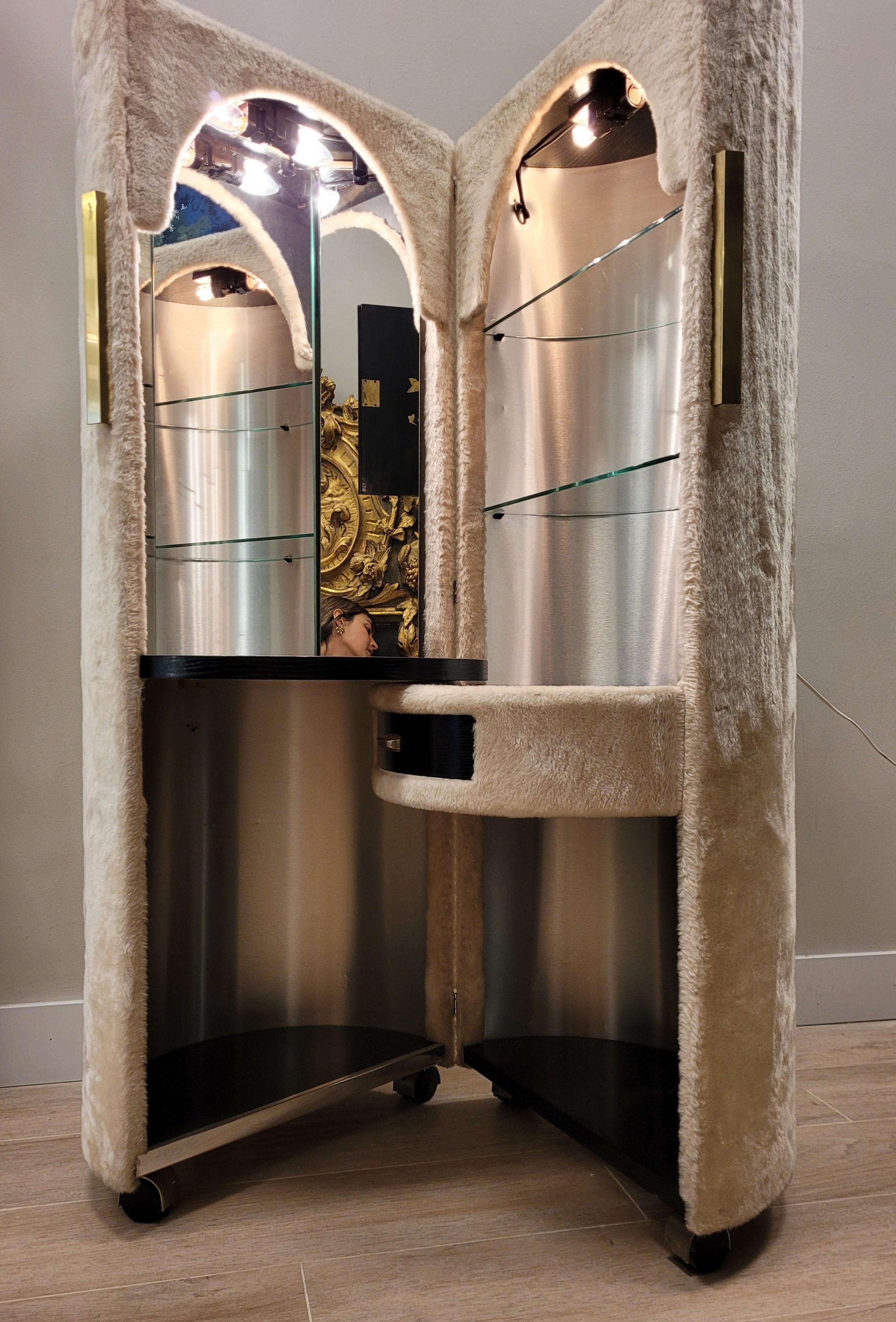 Gorgous , sophisticated and charming folding dressing table by Luigi Massoni for Poltrona Frau. It is a sophisticated piece with a cylindrical shape, upholstered with light beige velor / plush. Each half cylinder has interior lighting. It has