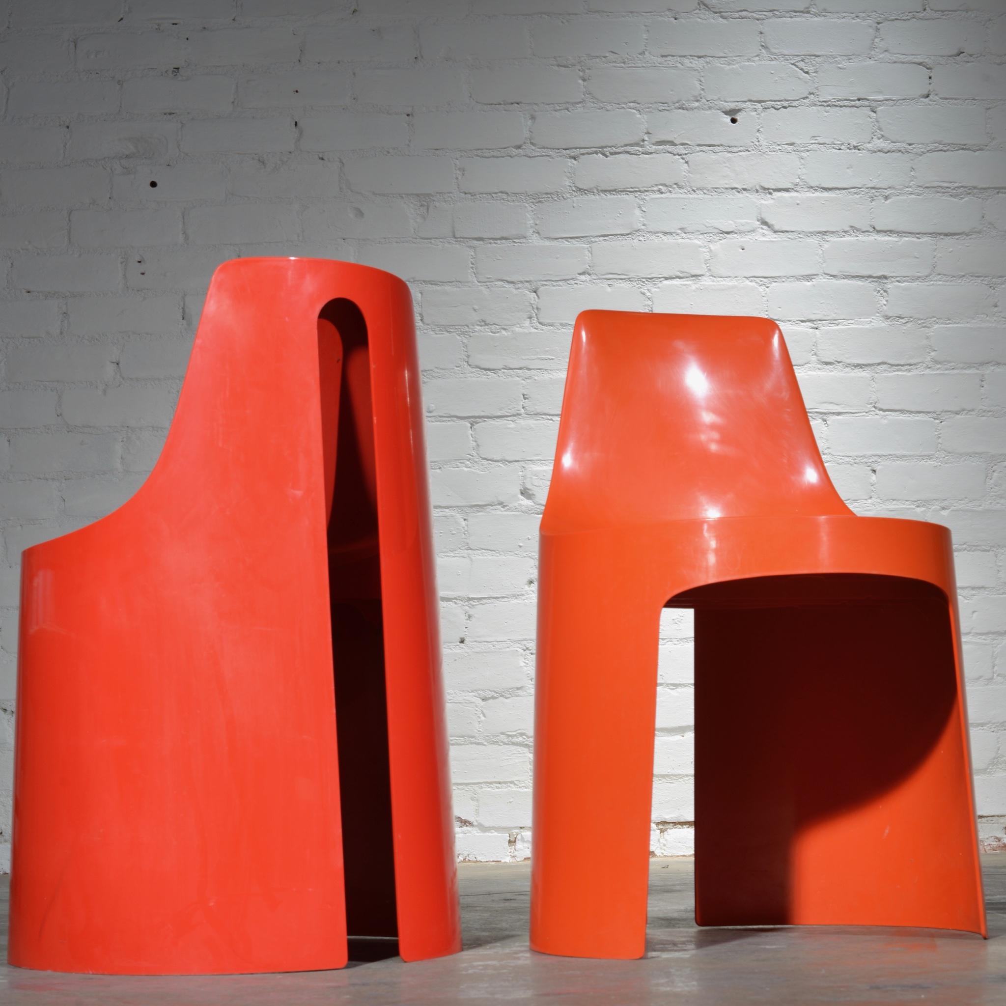 2 orange/ red modular plastic chairs, easily configured, reconfigured or stacked coming from Kay Ruggles Umbo furniture line. 
 



 