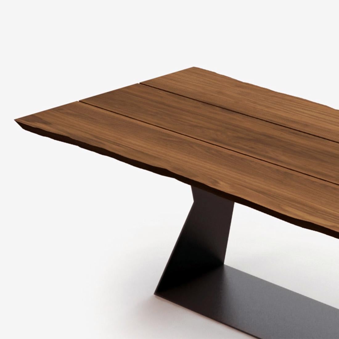 Dining table umbra with solid walnut wood top 
with 3 slats with middle gaps and with natural 
edges, with lacquered iron base.
Also available on request with solid oak top.
Also available on request in:
L200xD100xH76cm, price: