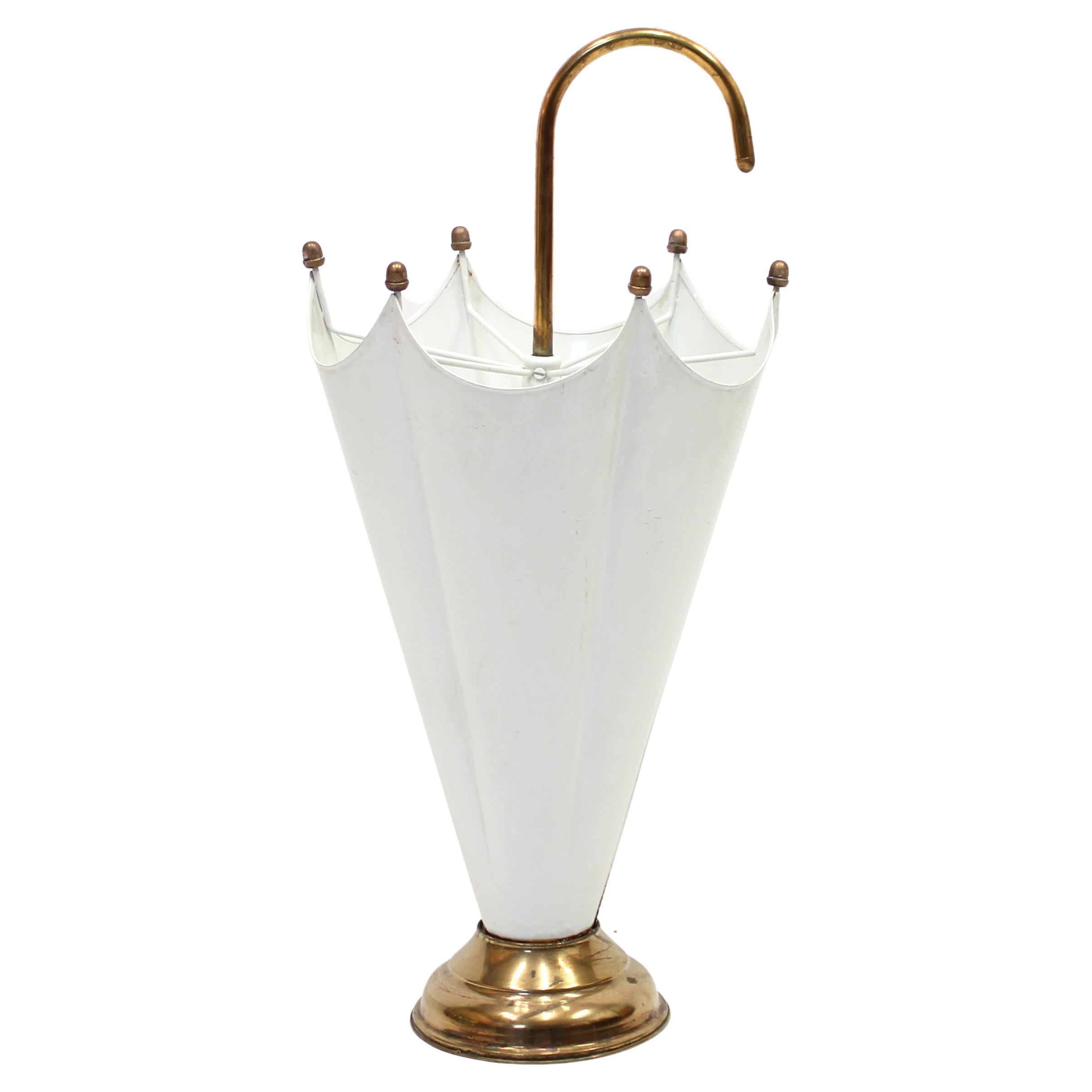 Cool umbrella stand in brass and white paint made i the 1970s. Possibly Italian. Base, handle and nobs i brass with the 