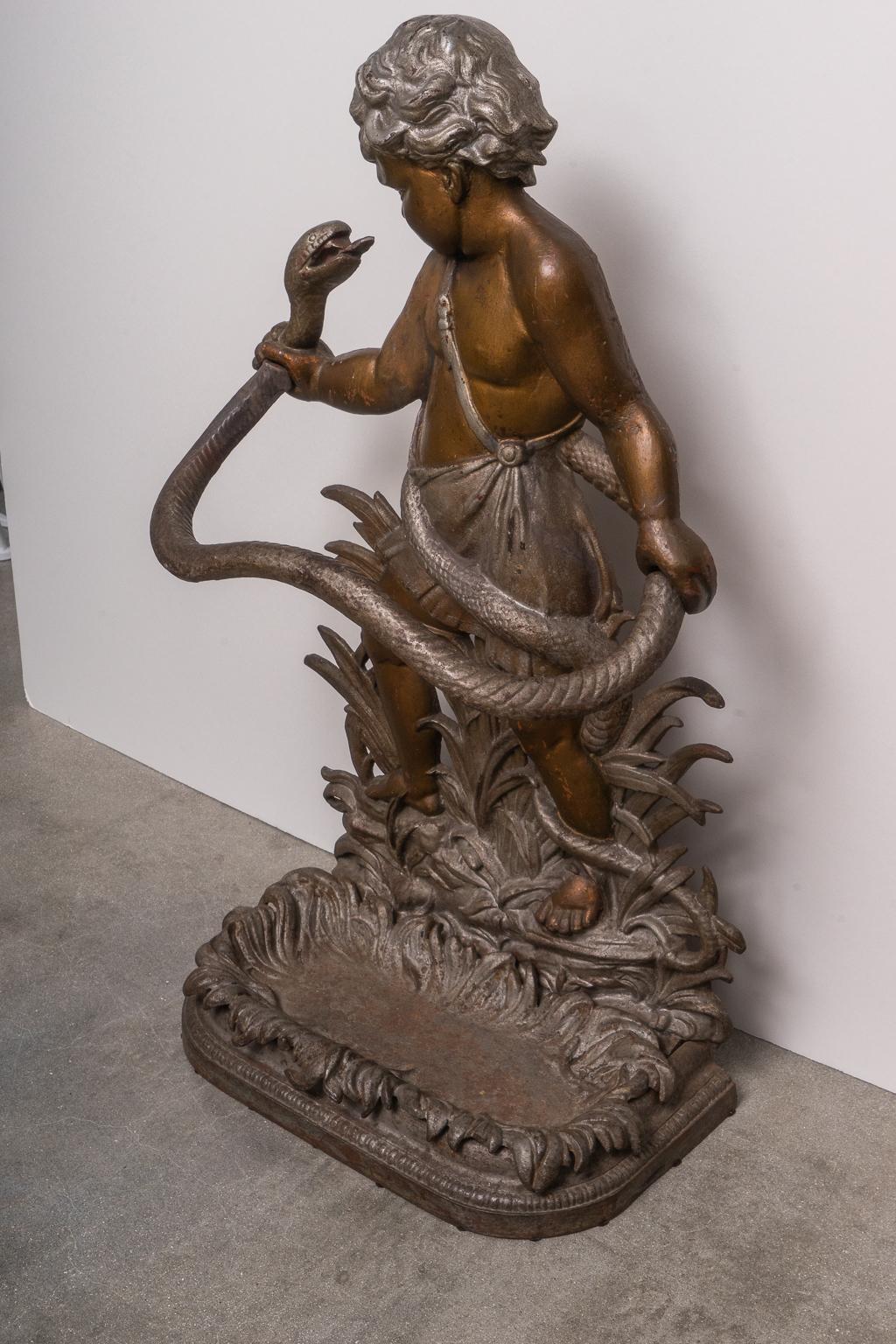 This stylish and substantial cast iron umbrella stand dates to the mid-19th century and is detailed with a young Hercules battling a large snake. The piece was created by the British firm of Edwin & Theophilus Smith.