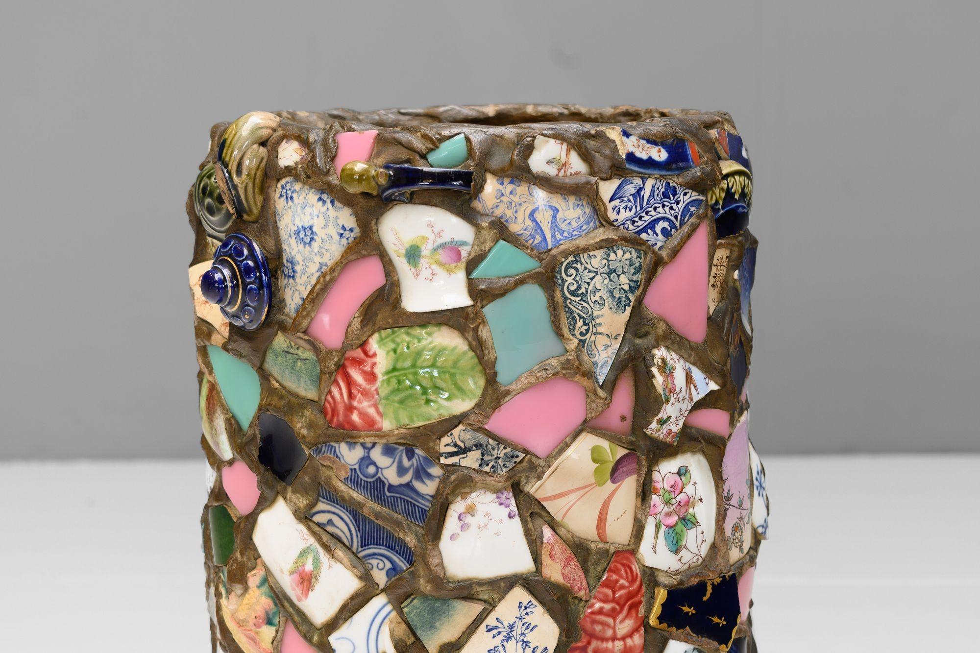 Terracotta umbrella stand with applied pottery shard decoration. Circa 1900.

H 59cm x W 30cm x D 27cm