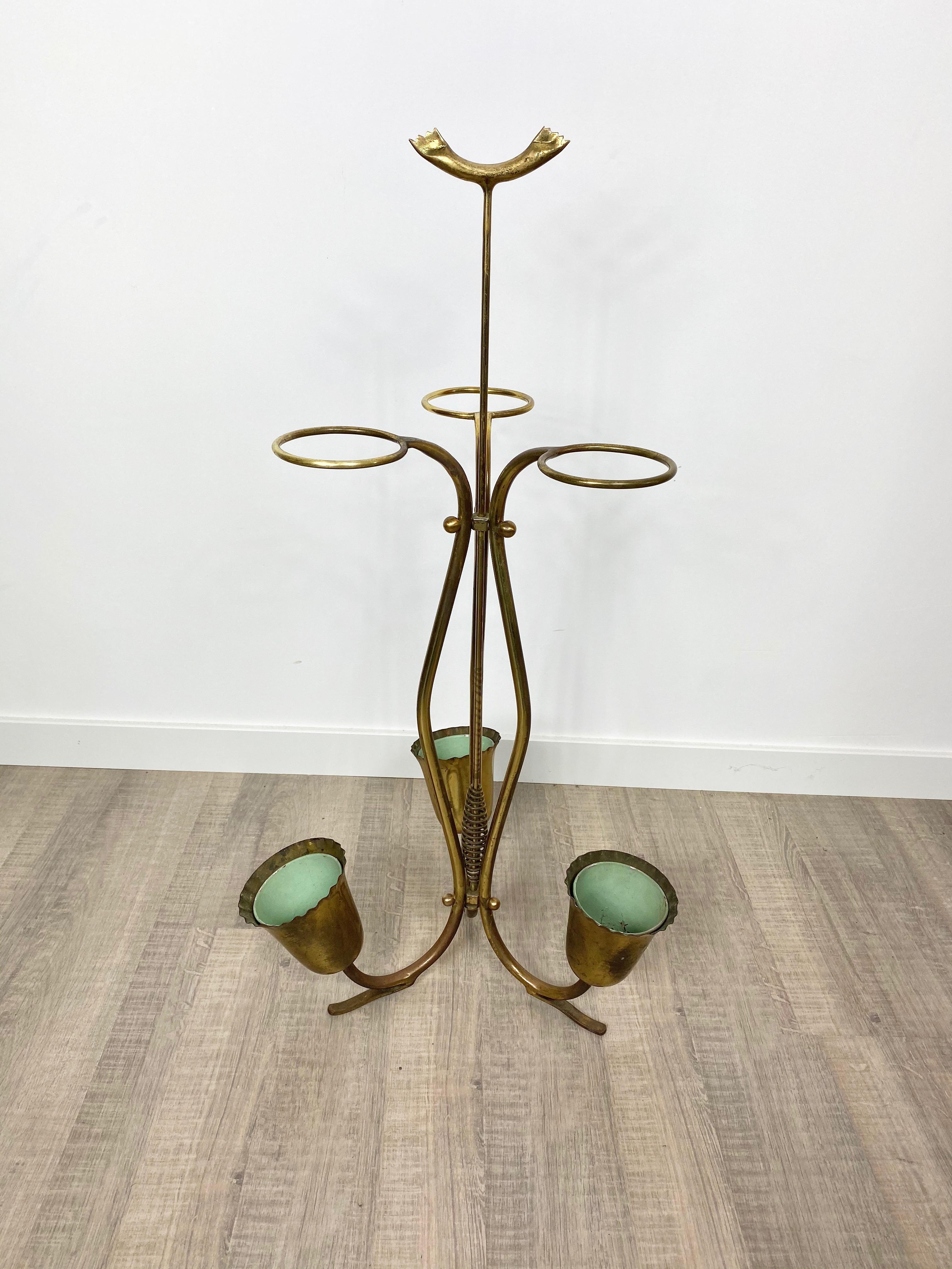 An elegant umbrella stand made in brass by the Italian designer Osvaldo Borsani from the 1950s. Structure with three legs, with small cups in the part below and brass empty circle not only aesthetical but also functional to insert the umbrellas.