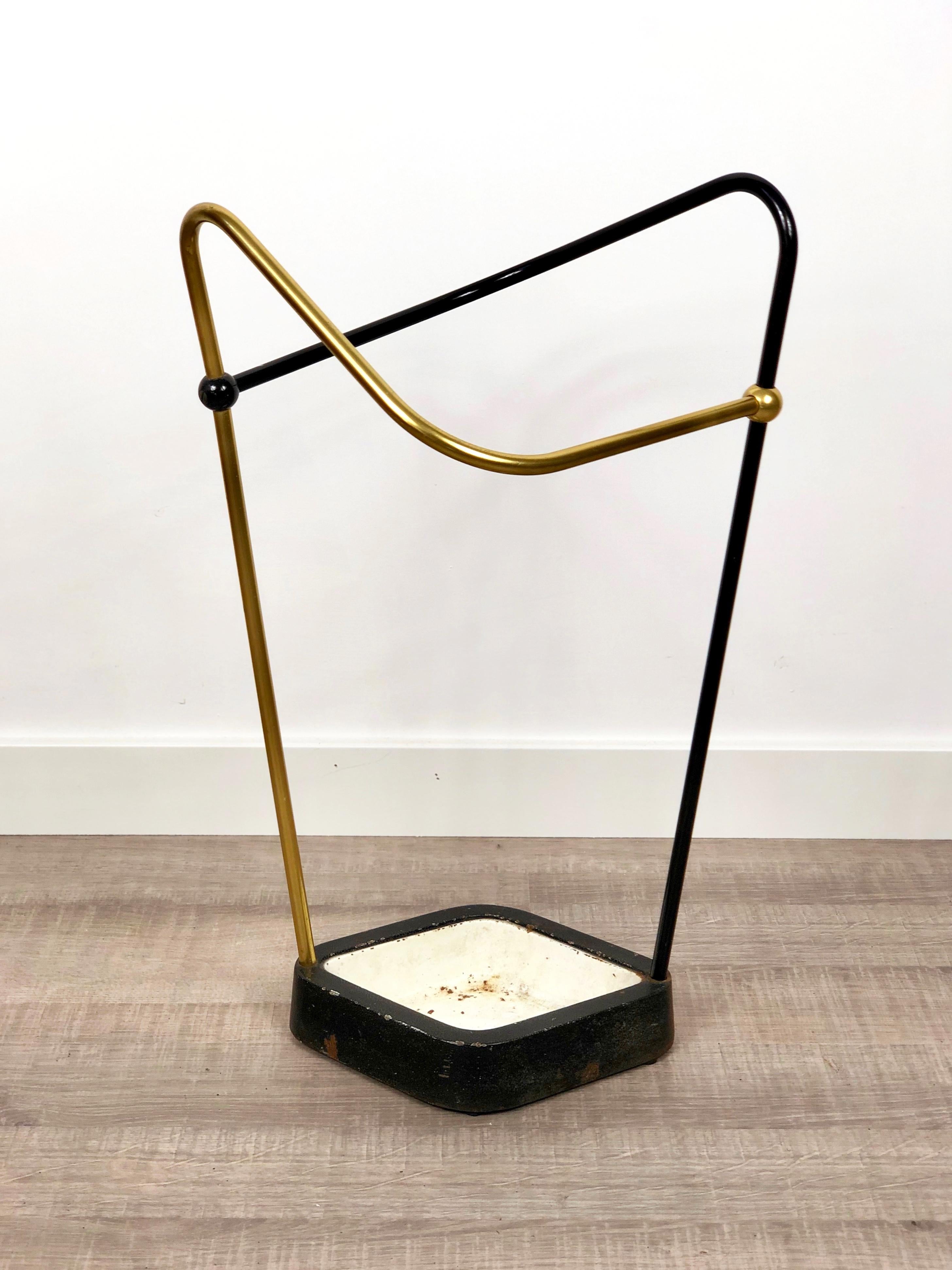 This original vintage Bauhaus style umbrella stand was produced in the 1950s in Germany. The brass colored top elements is made of aluminium, the heavy metal base element is made of cast iron. Straightforward and minimalistic design of the Bauhaus