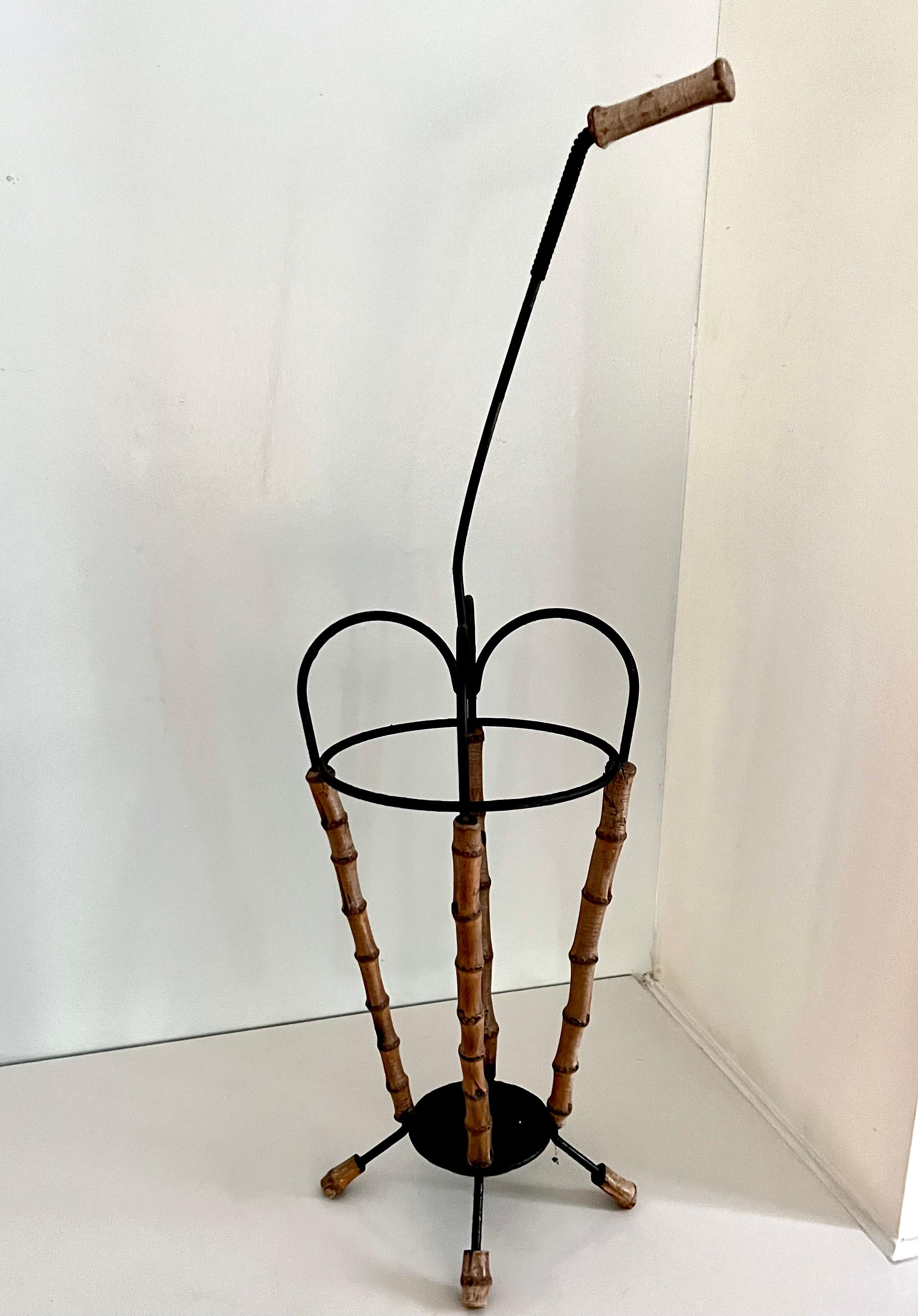 Unique mid-century footed umbrella holder with bamboo detail and handle. 
A complement to any entryway and a comfort on rainy days. 
Black finish on the metal. The piece is rather light weight but great for areas that need a delicate touch and not