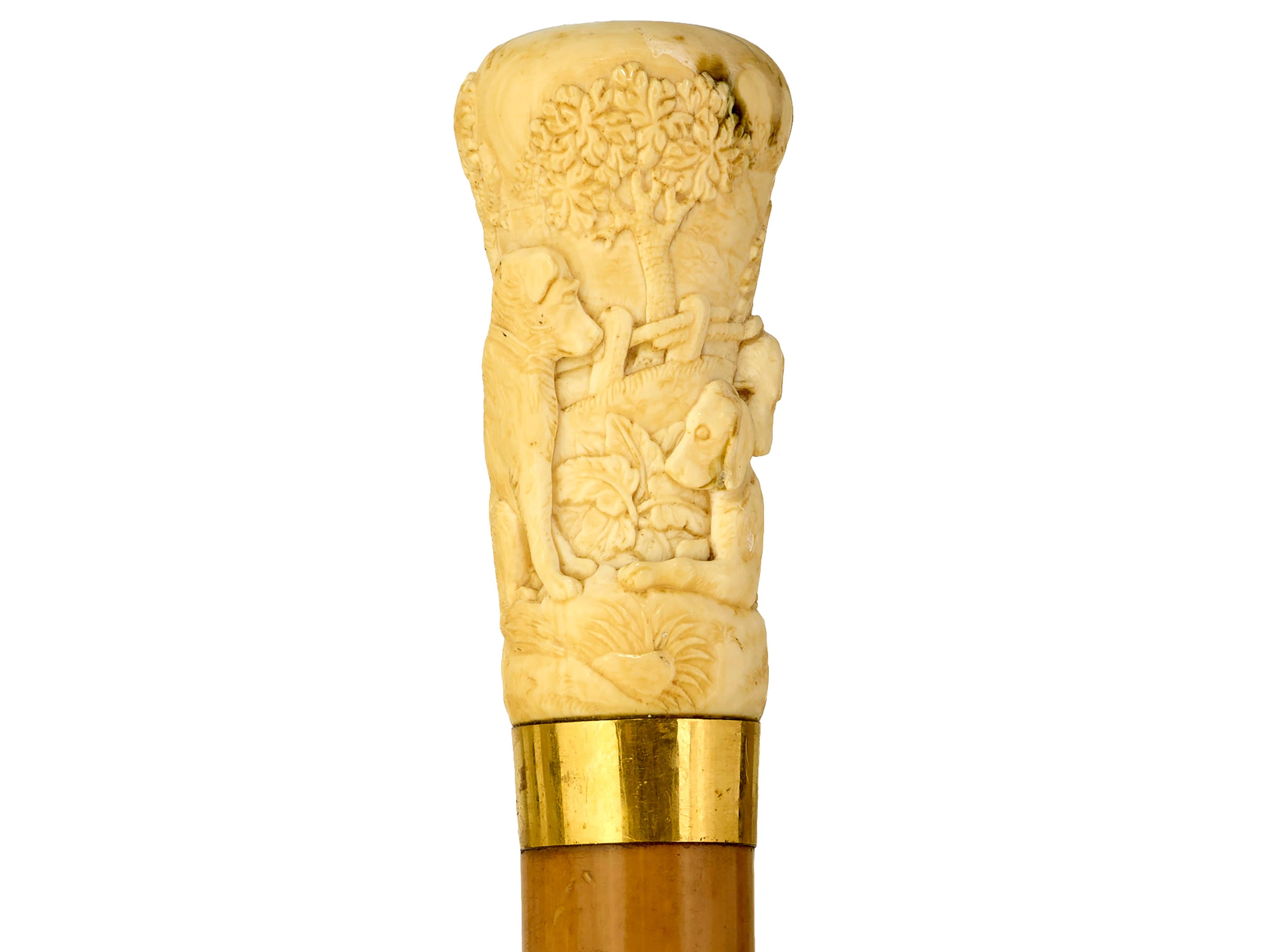 Umbrella with carved hunting hounds
Gold coloured collar marked Briggs. Ivory top finely carved with four hunting hounds under trees. Original ferrule and worn umbrella. 
Will be supplied with Ivory Submission Reference No.
L 94cm, round top 3.5cm