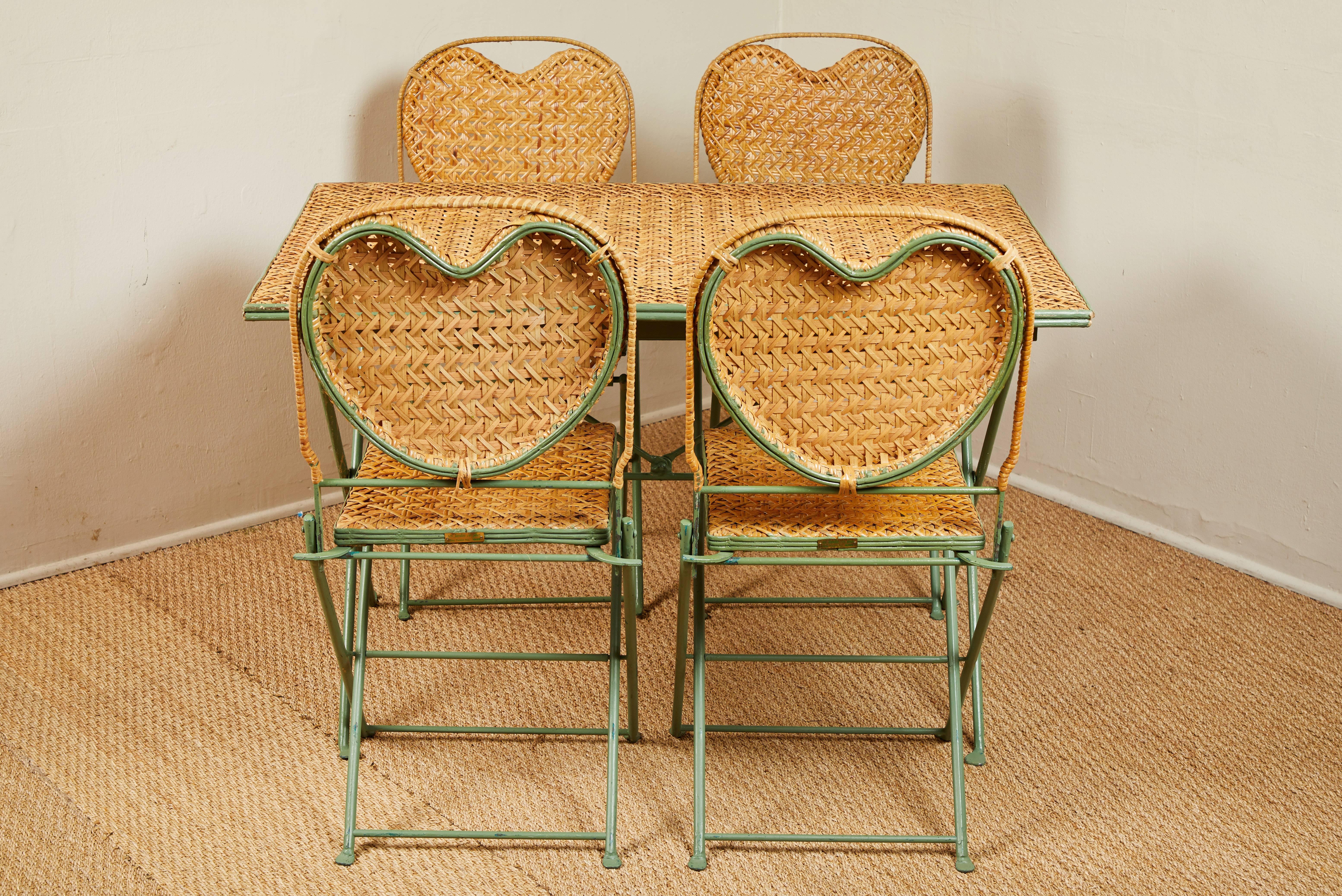 Patented folding table and chair set made in USA by Un Jardin en Plus. See image 12 for metal tag. Heart shaped caned backs on the chairs. Slightly distressed turquoise blue painted metal.
 