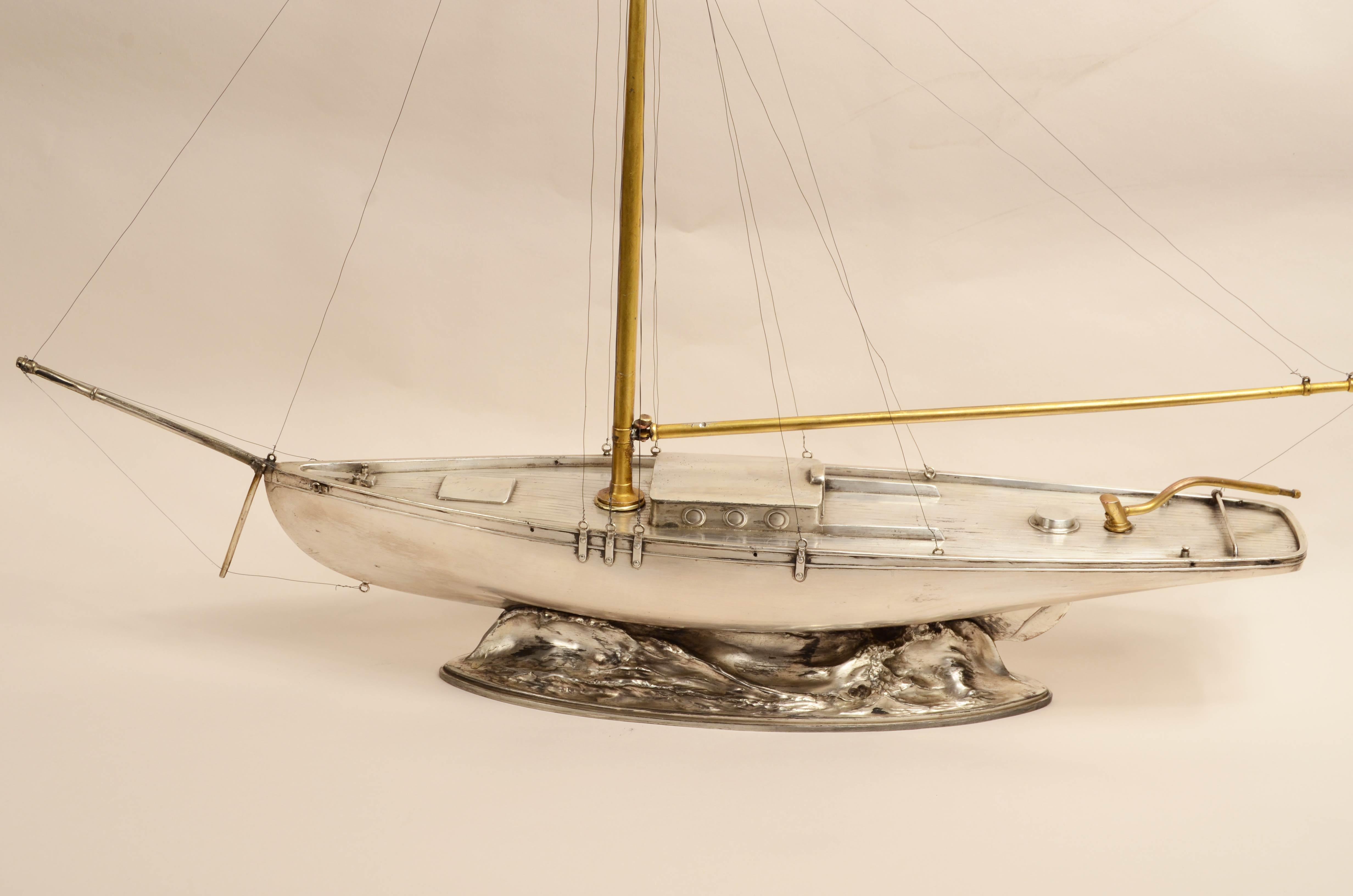 Very rare and fine early 20th century scale model of a Cutter, valuable  white metal lost-wax casting of a small pleasure sailing ship, the base also made of white metal simulates wave motion.
The white metal is a tin alloy with a small percentage
