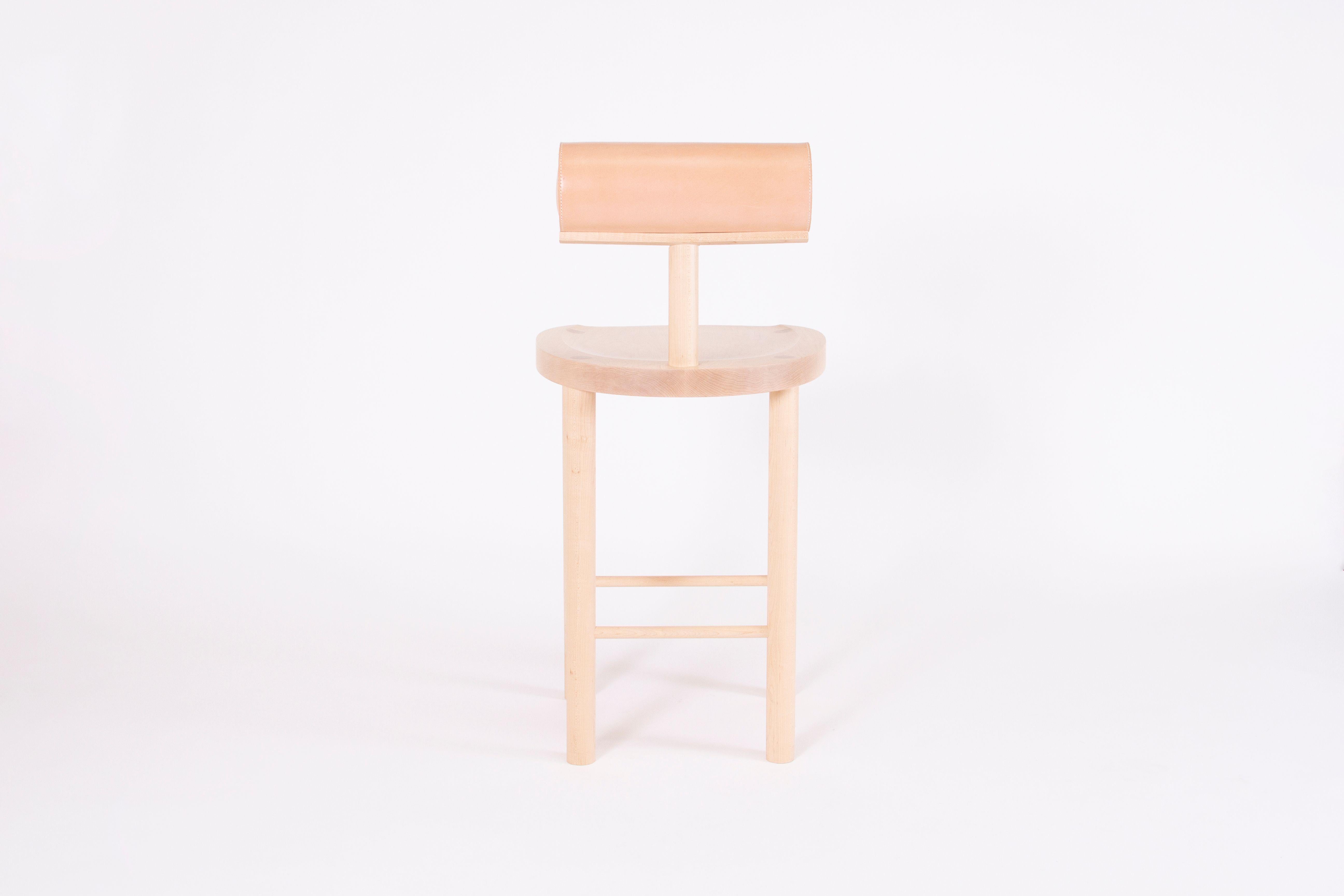 Una counter stool by Estudio Persona
Dimensions: W 45.8 x D 48.3 x H 94 cm
Materials: Solid maple, natural vegetable leather

Solid maple, upholstered back bolster in natural vegetable leather.
Also available in black stained ash or