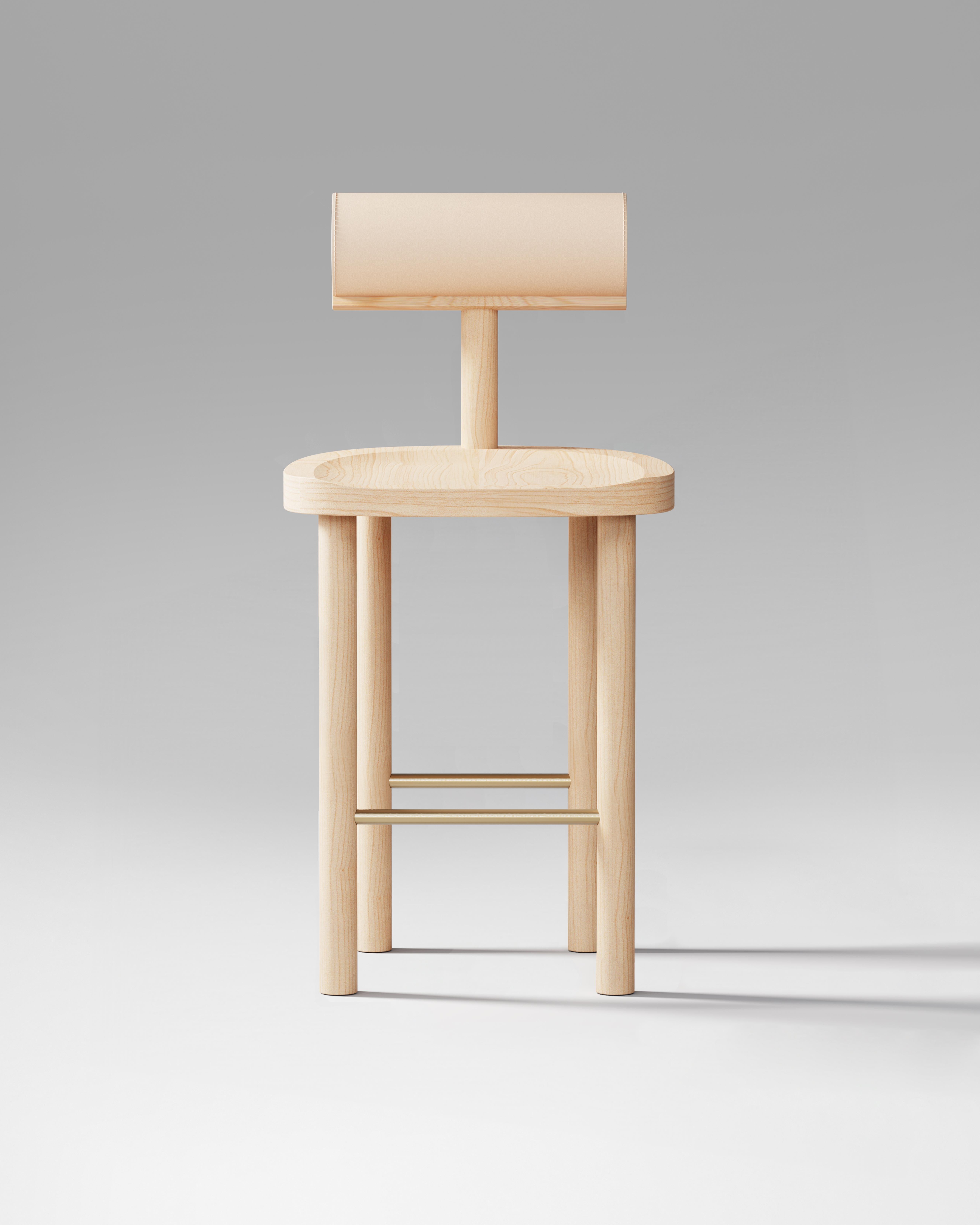 Lo sgabello da banco UNA combina una seduta e delle gambe in legno curvato con uno schienale cilindrico rivestito in pelle, creando un equilibrio tra comfort e geometria semplice. Il suo design mette in risalto la bellezza naturale delle venature
