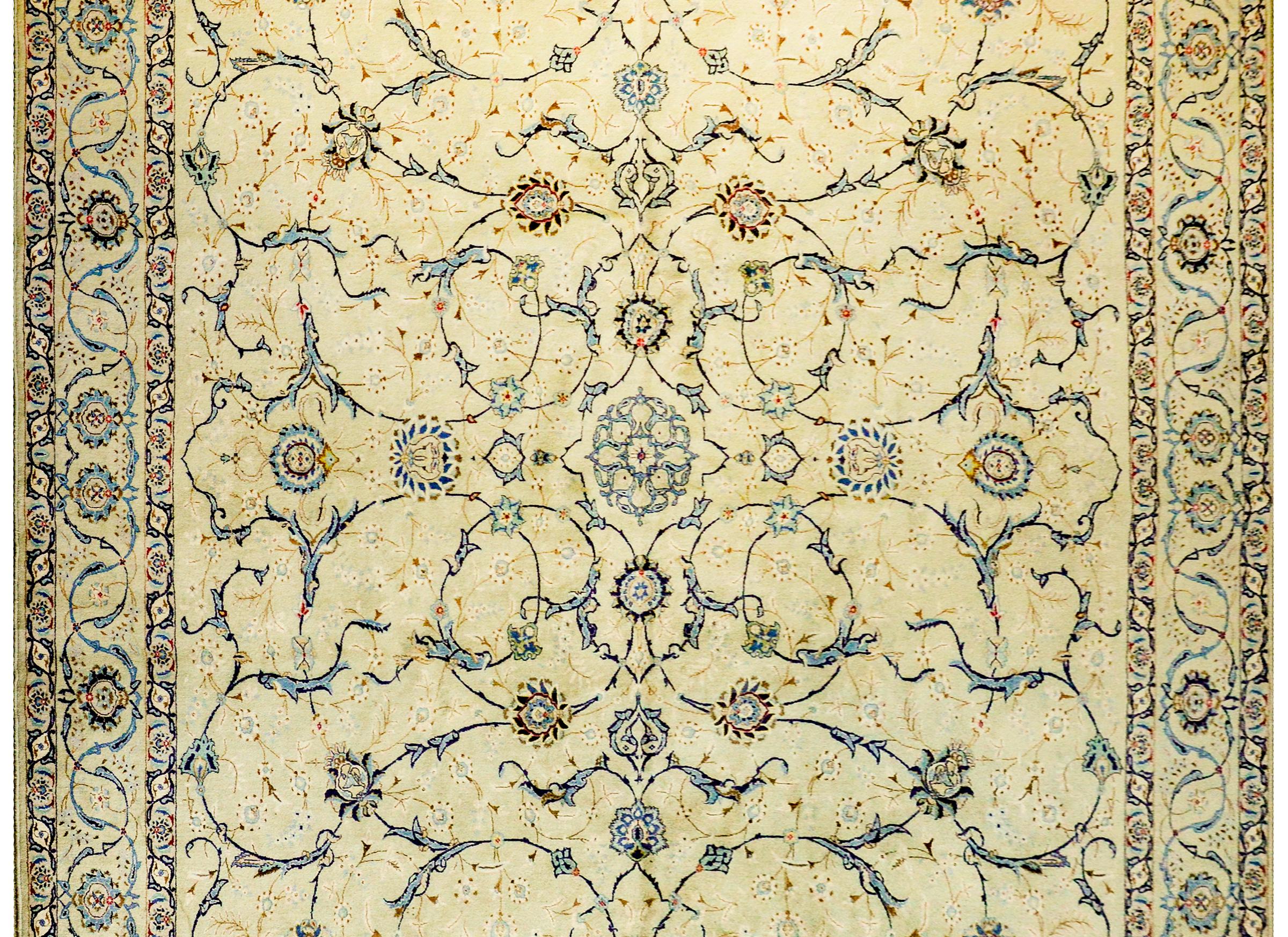 An unbelievable early 20th century Persian antique Kashan rug with an amazing and skillfully rendered pattern with a mirrored lacy scrolling vine and floral design, woven in crimson, indigo, gold, and white wool on a beautiful champagne colored