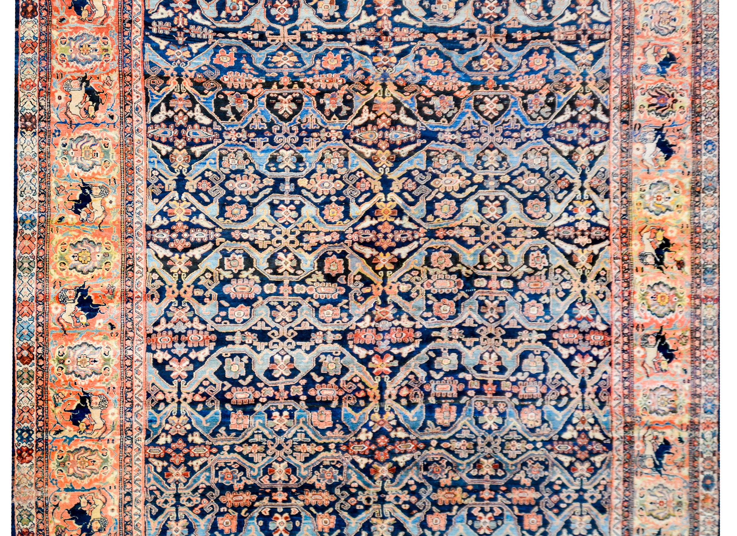 An unbelievable early 20th century Persian Sultanabad rug with a fantastic tribal pattern with a densely woven field of stylized flowers with a lacy trellis pattern woven with an abrash indigo color. The border is fantastic with a wide stripe