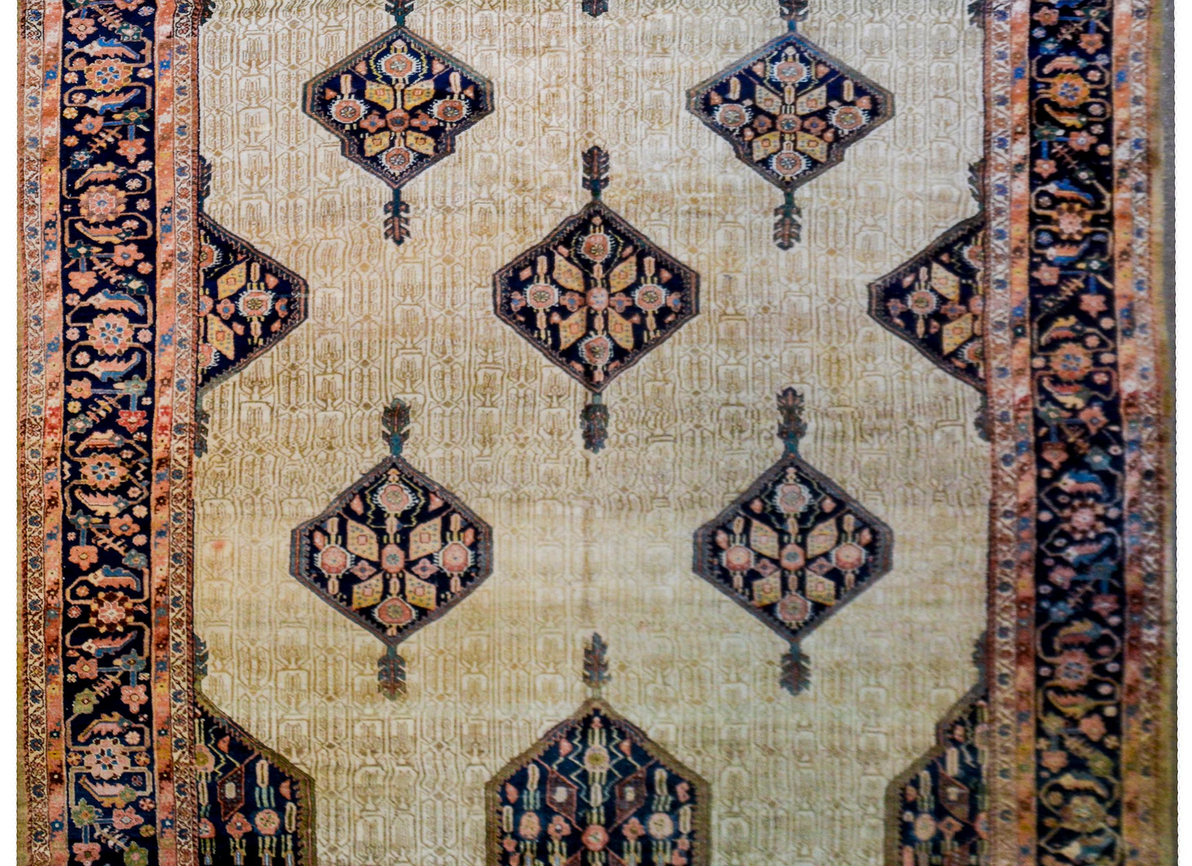 An unbelievable late 19th century monumental Persian Serab rug with an incredible field containing multiple diamond-form and floral and indigo medallions floating on a cream colored background with a micro tone on tone floral pattern. The border is