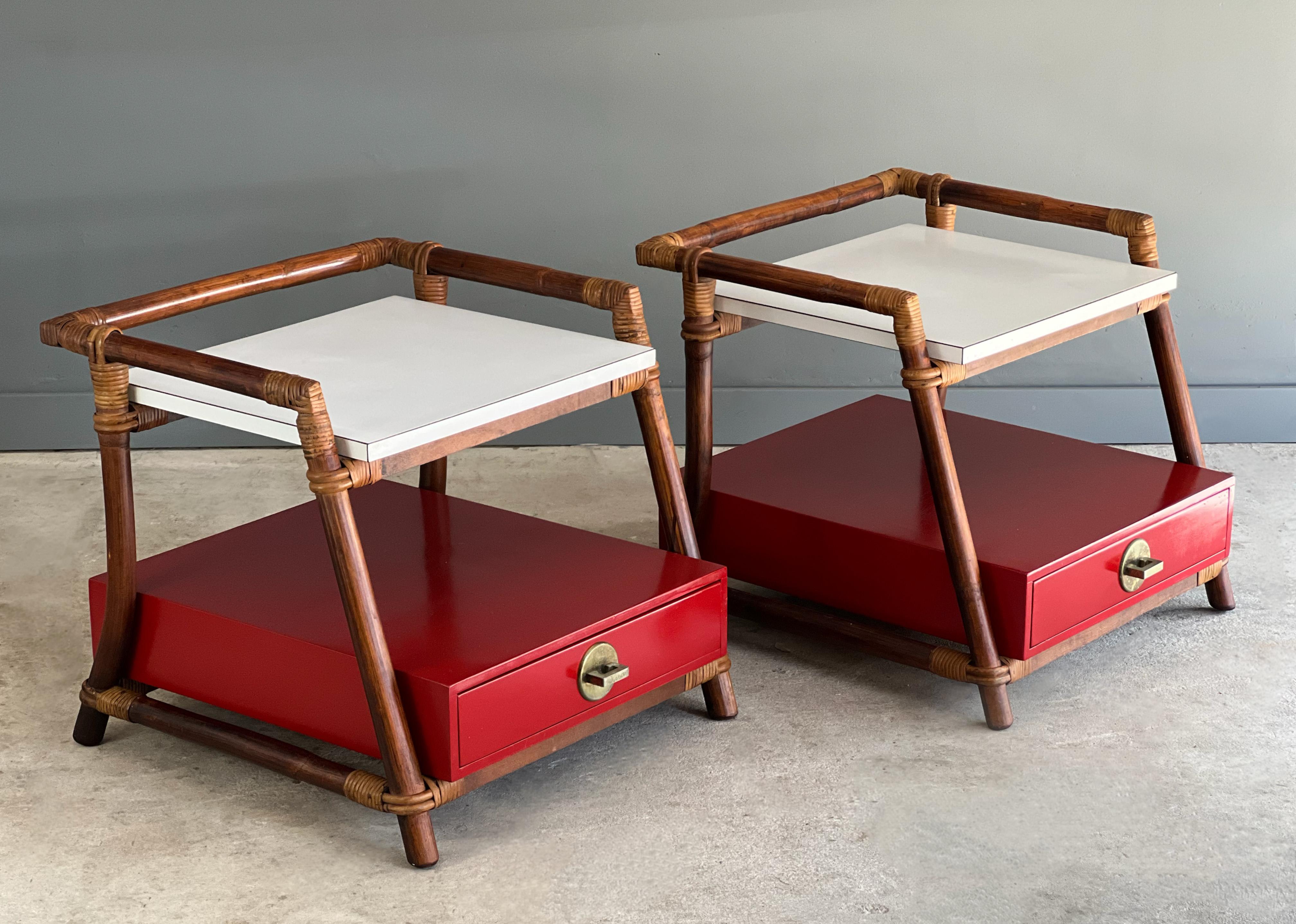 Pair of not often seen side tables or nightstands by Ficks Reed. Likely designed by John Wisner, these are a perfect compliment of color to any space. Each table features a “regal red” drawer box with brass pull and a white laminate top shelf.