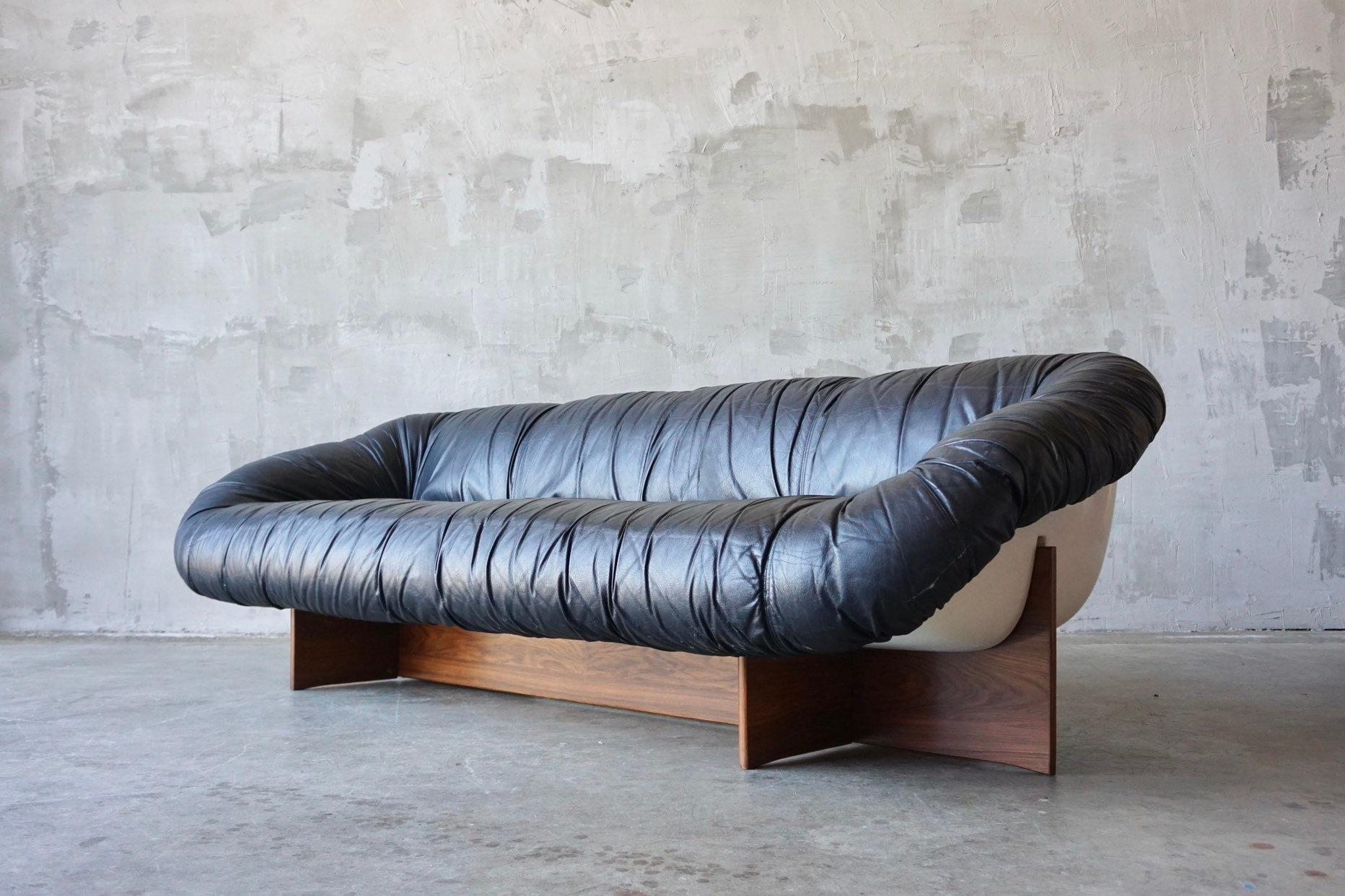 Uncommon sofa designed by Percival Lafer, circa 1970s. Constructed with a leather upholstered molded fiberglass ‘pod’ supported by rosewood ply base. 

Sits extremely comfortable with a low, lounge and deep seat feel. 

Excellent overall