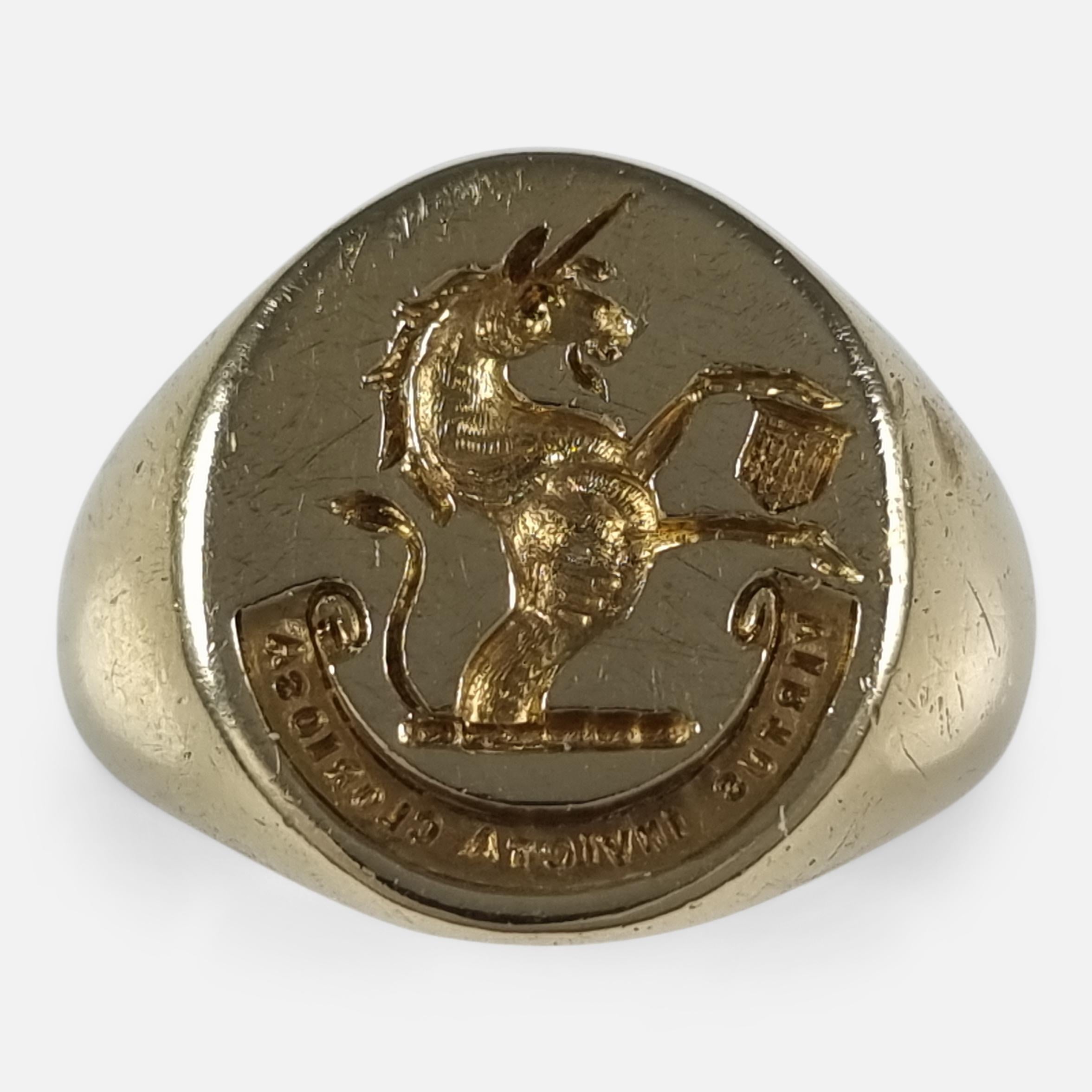 An Elizabeth II signet ring crafted in 18ct yellow gold. It features an oval-shaped head, engraved with an intaglio of a demi-unicorn beside a shield, representing the Thomas family crest. Below this is the Latin inscription 'VIRTUS INVICTA