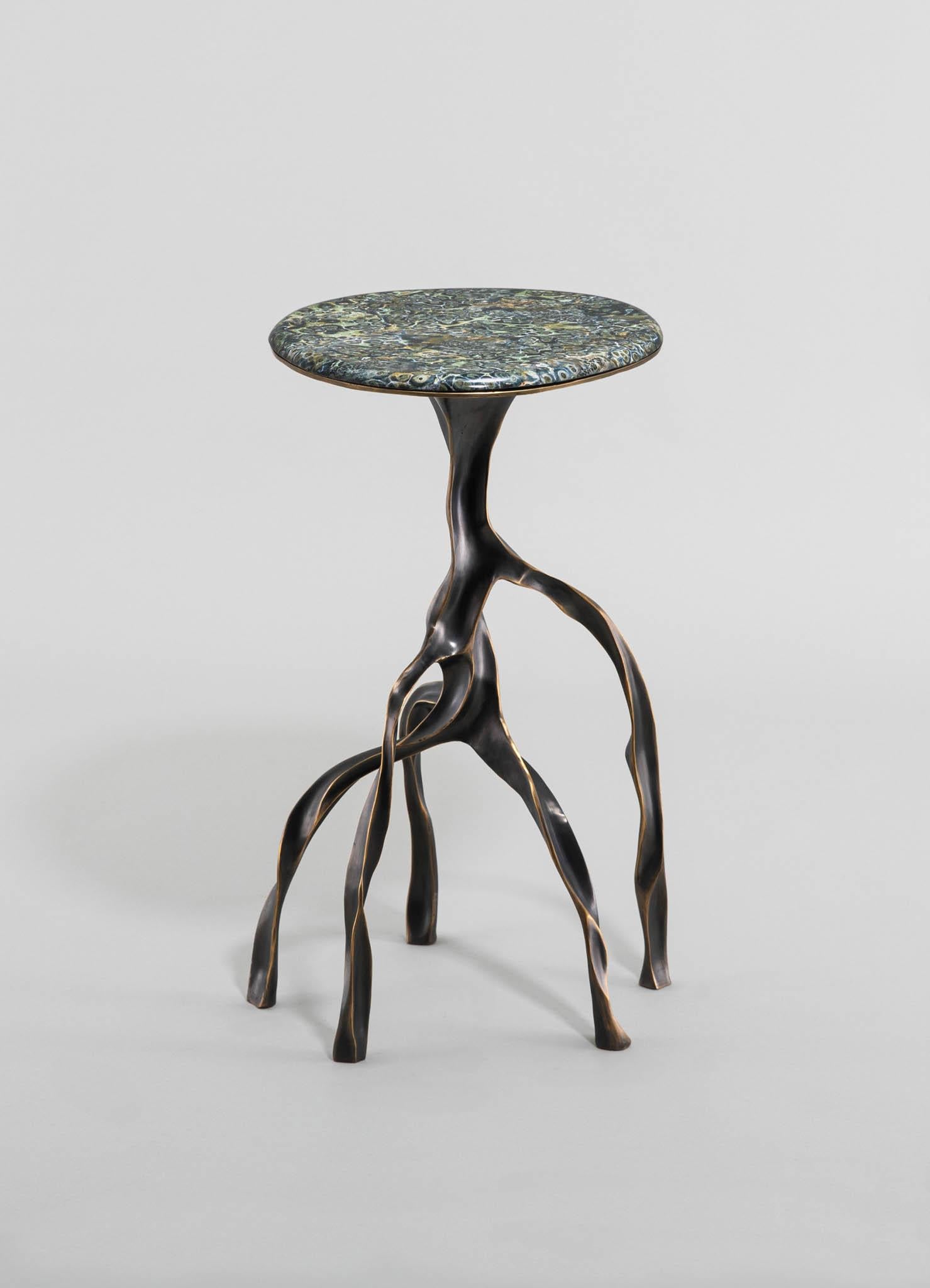 Faisant écho à d'anciens chuchotements d'adoration, chaque objet capture l'essence de l'arbre Banyan, censé détenir le pouvoir divin d'exaucer les souhaits. Fabriqués avec Revere, ces objets en laiton reflètent la danse complexe des racines
