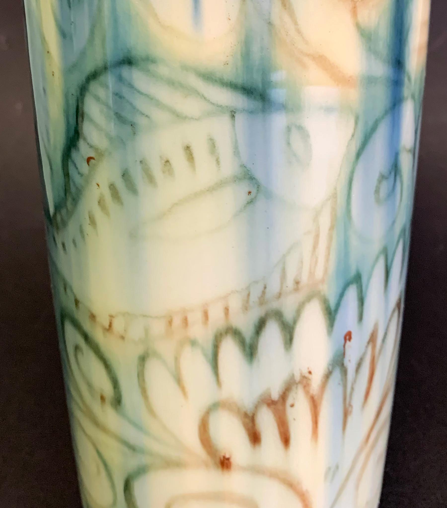 A marvelous, atmospheric example of Art Deco artisanry, this cylindrical vase by Jens Jensen for Rookwood Pottery depicts a fish swimming amidst moving water and tendrils of seaweed, all lit by the shifting light and shadows cast by the sun above.